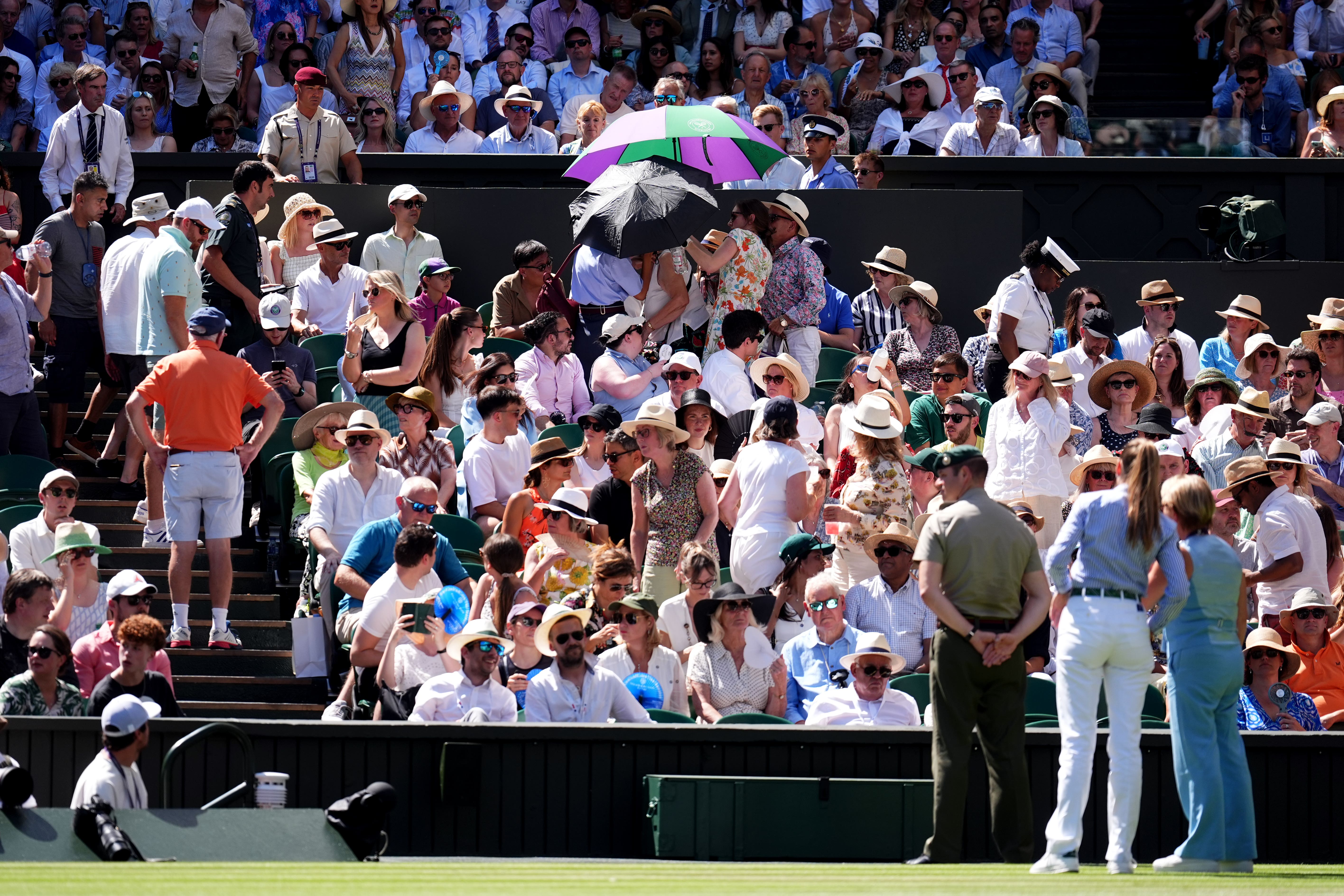 Stewards come to the aid of a spectator on centre court during the men’s singles semi-final between Taylor Fritz and Carlos Alcaraz at Wimbledon (Mike Egerton/PA)