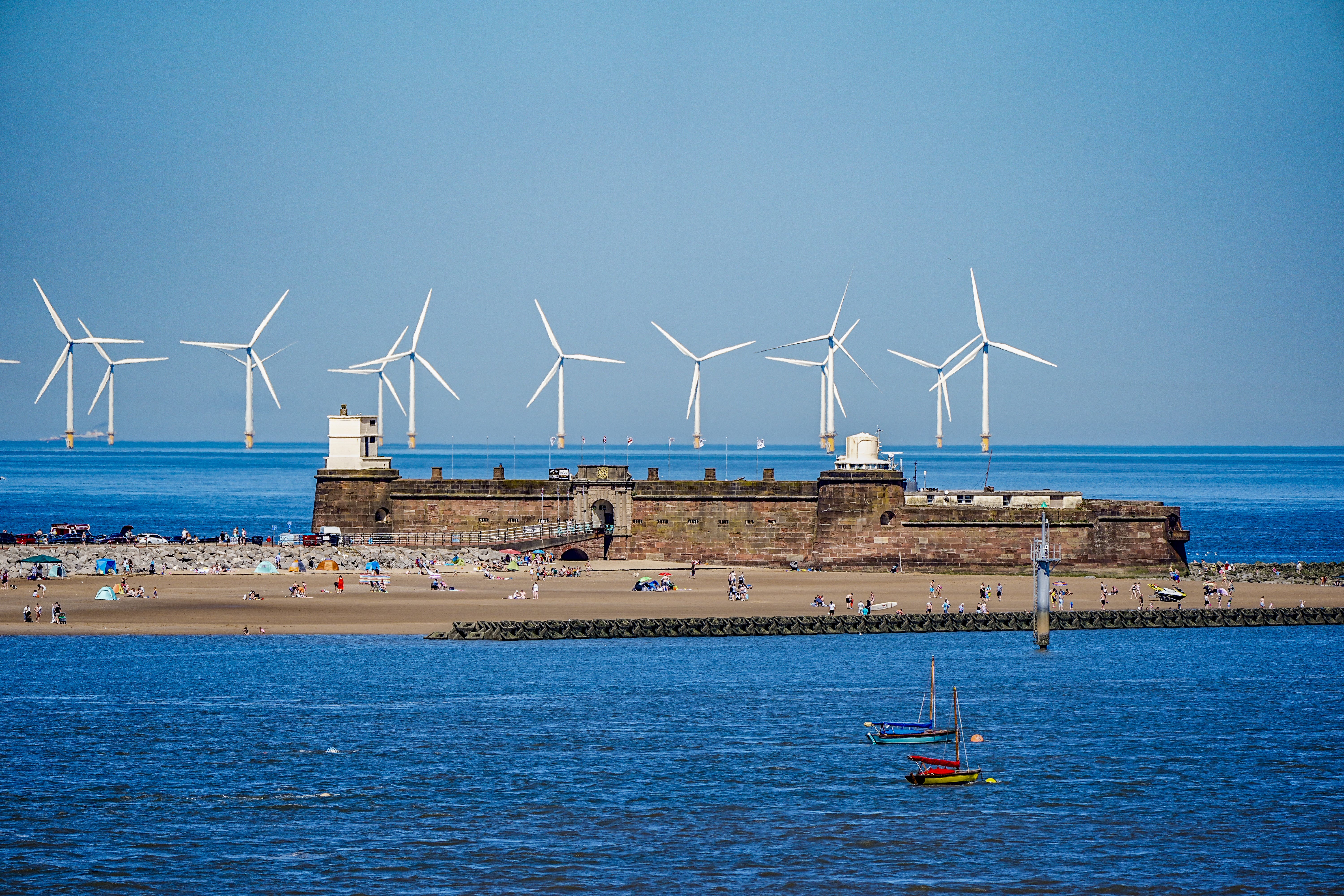 People on the beach at New Brighton on the River Mersey, as the third heatwave of the summer hits the UK (Peter Byrne/PA)
