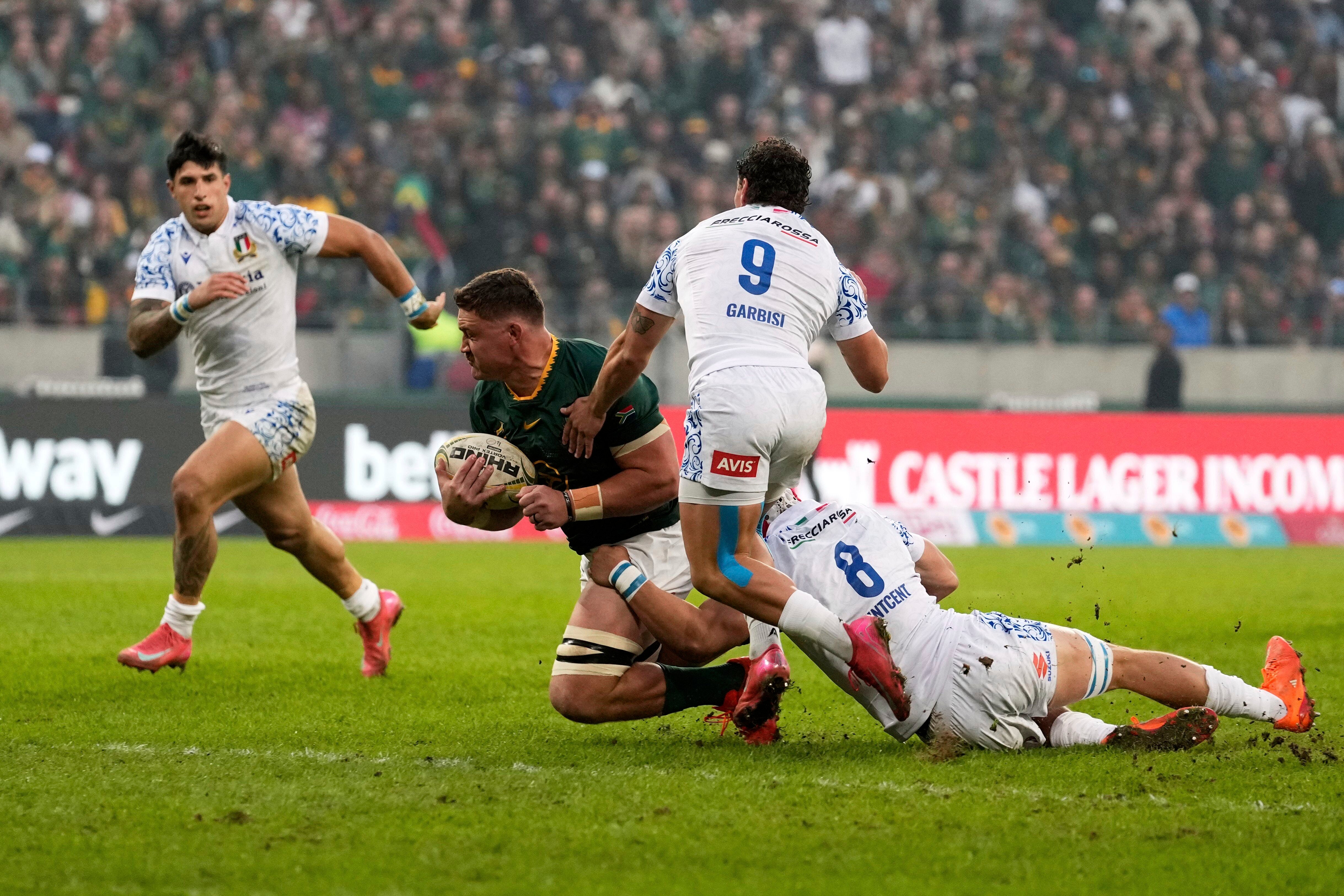 South Africa's Jasper Wiese, centre, is tackled by Italy's Ross Vintcent