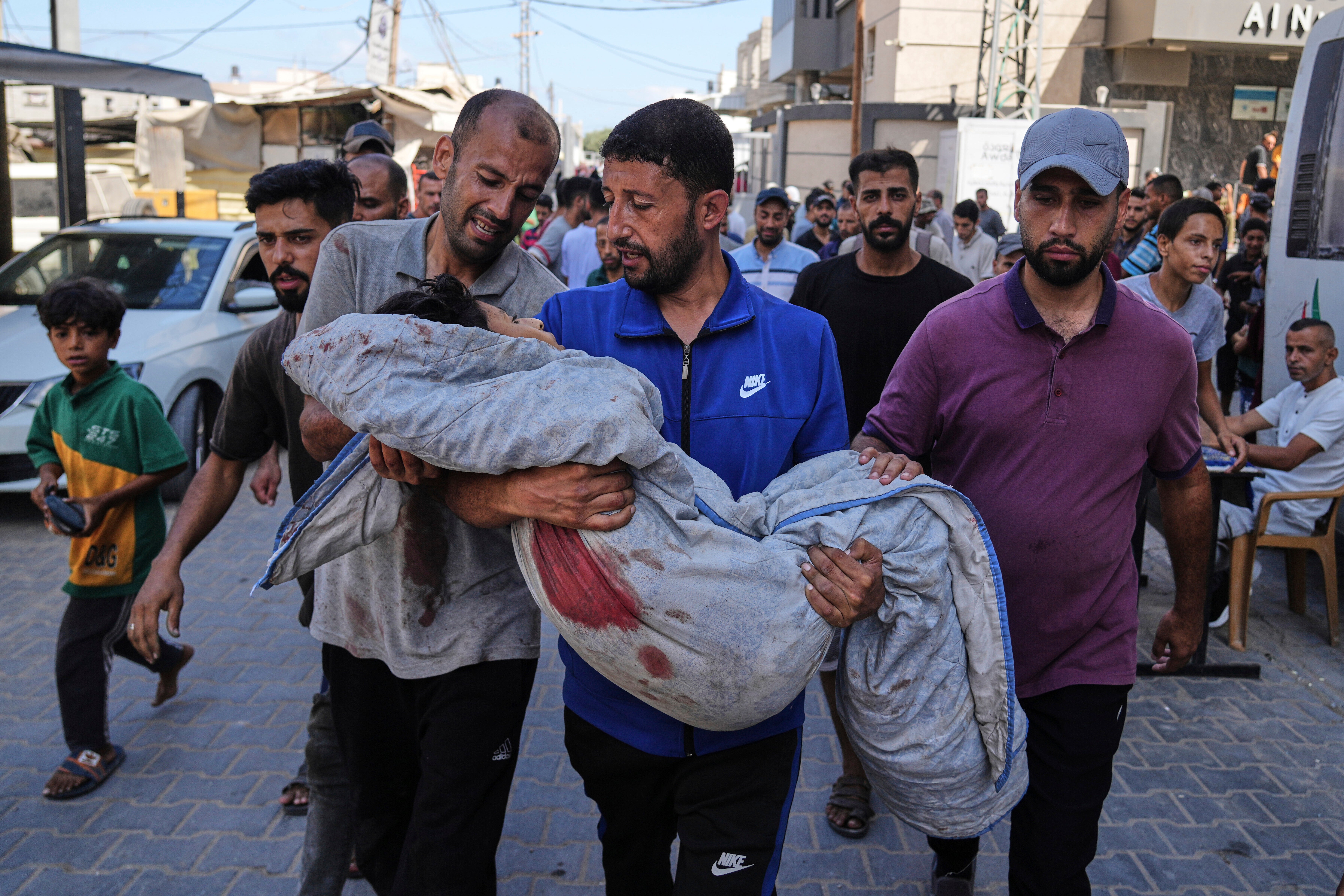 Relatives carry the body of 13-year-old Seraje Ebrahim, killed in an Israeli strike on a drinking water distribution point