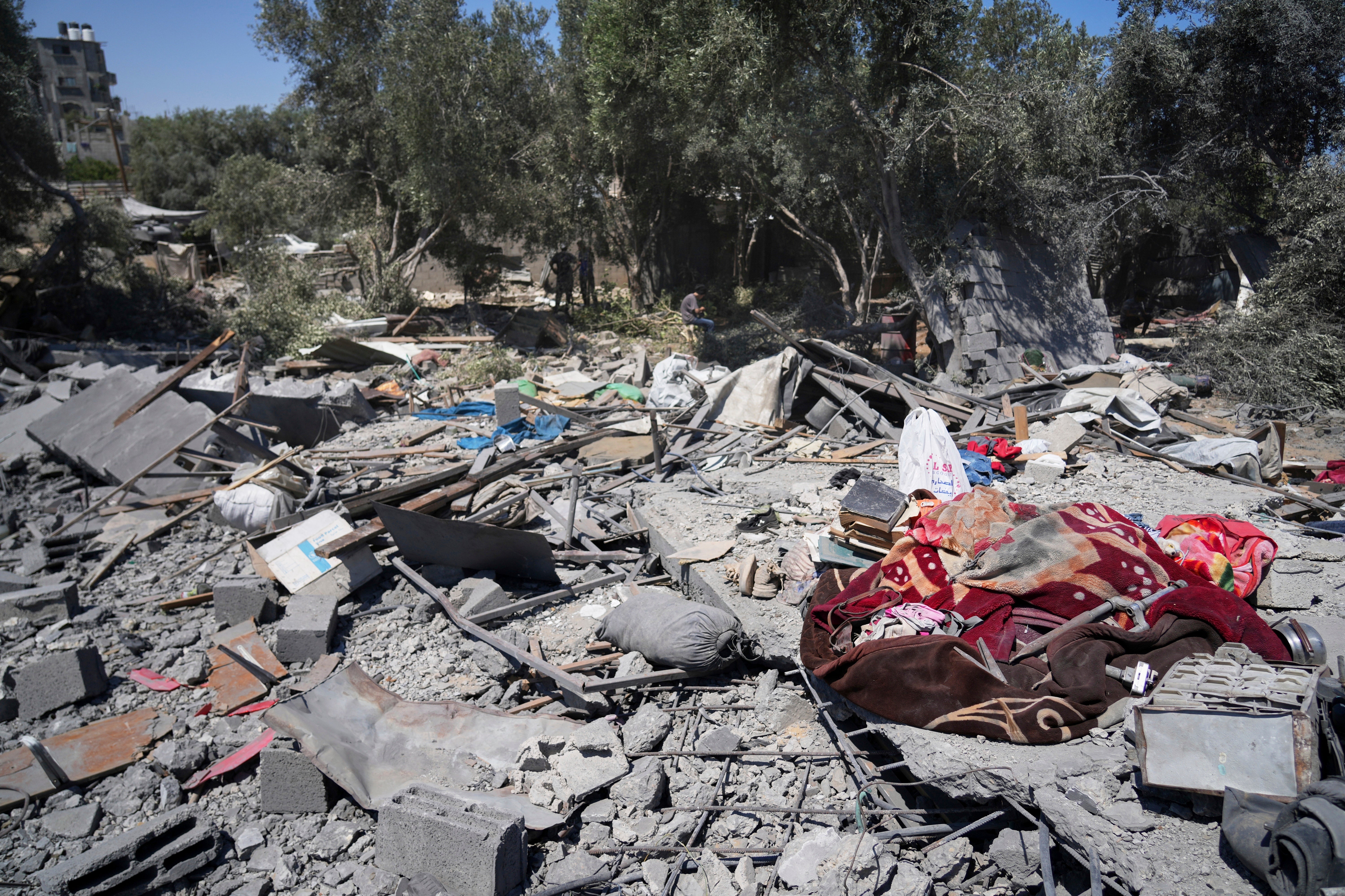 Palestinians inspect the site of an Israeli army strike on a house belonging to the Al-Arabid family which killed at least nine people in Al-Zawida, central Gaza Strip