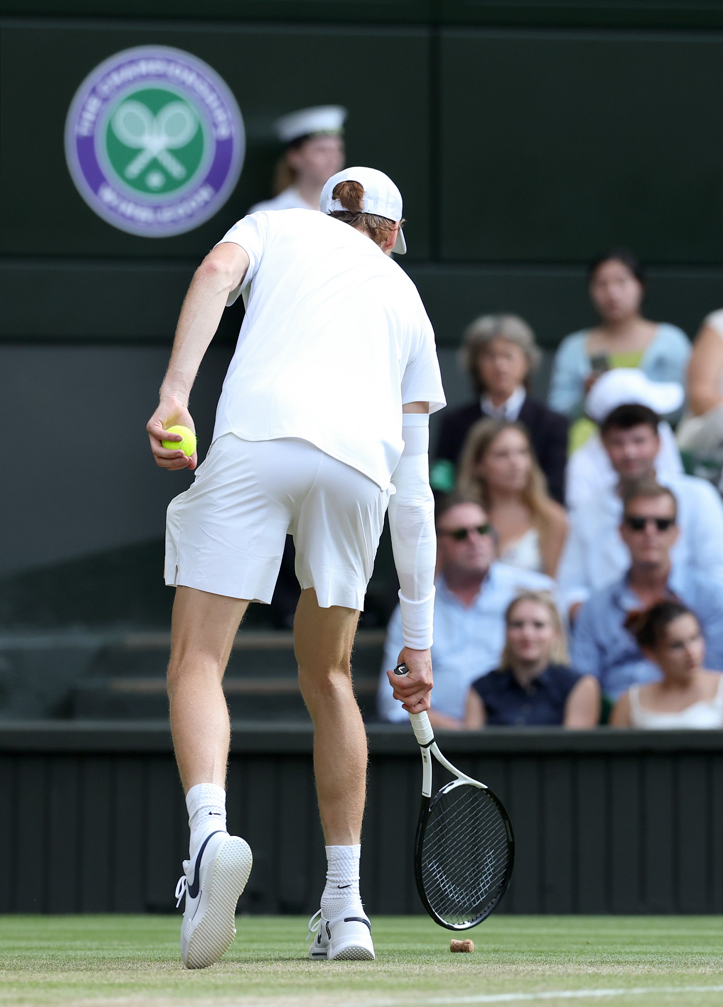 Jannik Sinner removes a champagne cork from Centre Court