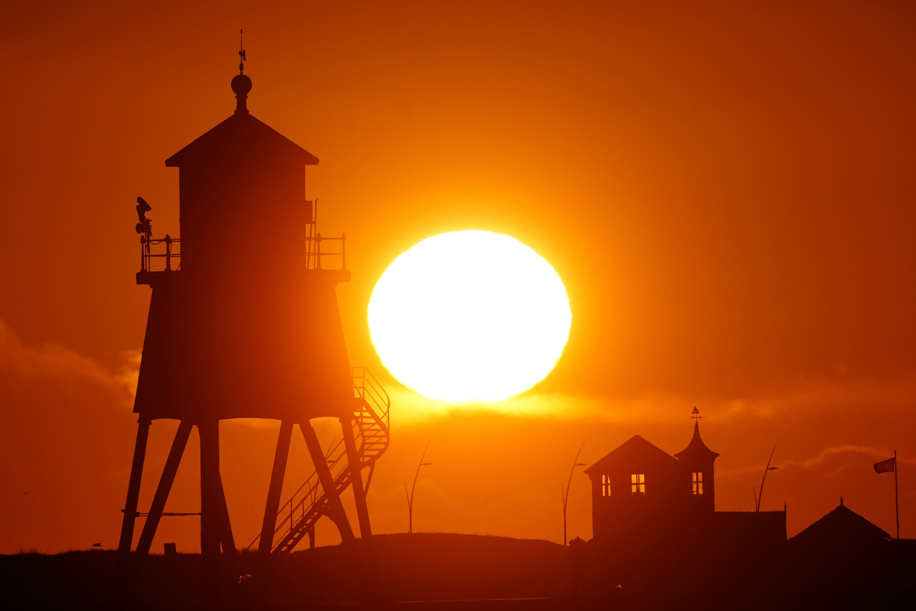 The sun rises over the Groyne lighthouse in South Shields, Tyne and Wear (Owen Humphreys/PA)