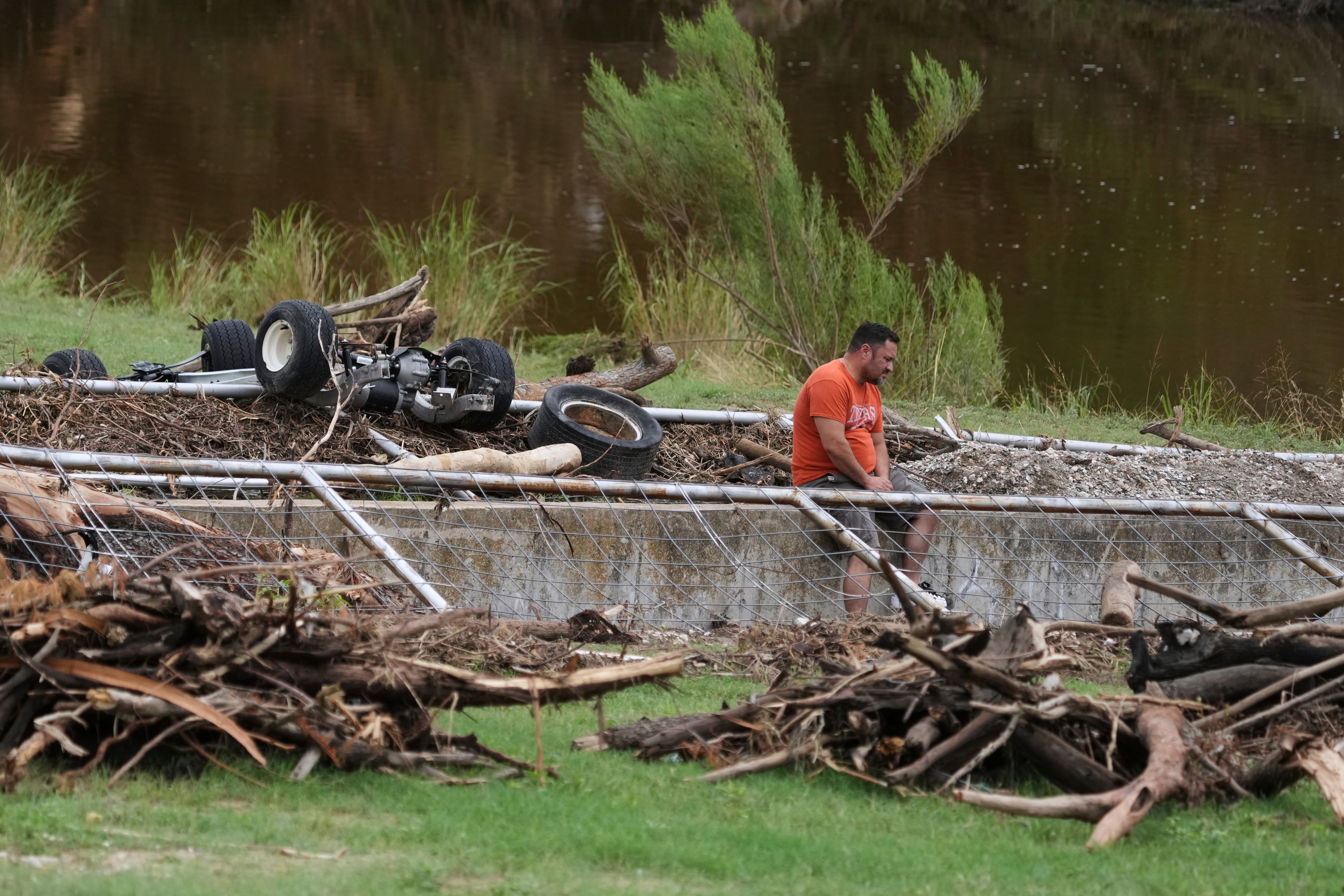 A man surveys debris and flood damage along the Guadalupe River, Sunday, July 13, 2025, in Kerrville, Texas