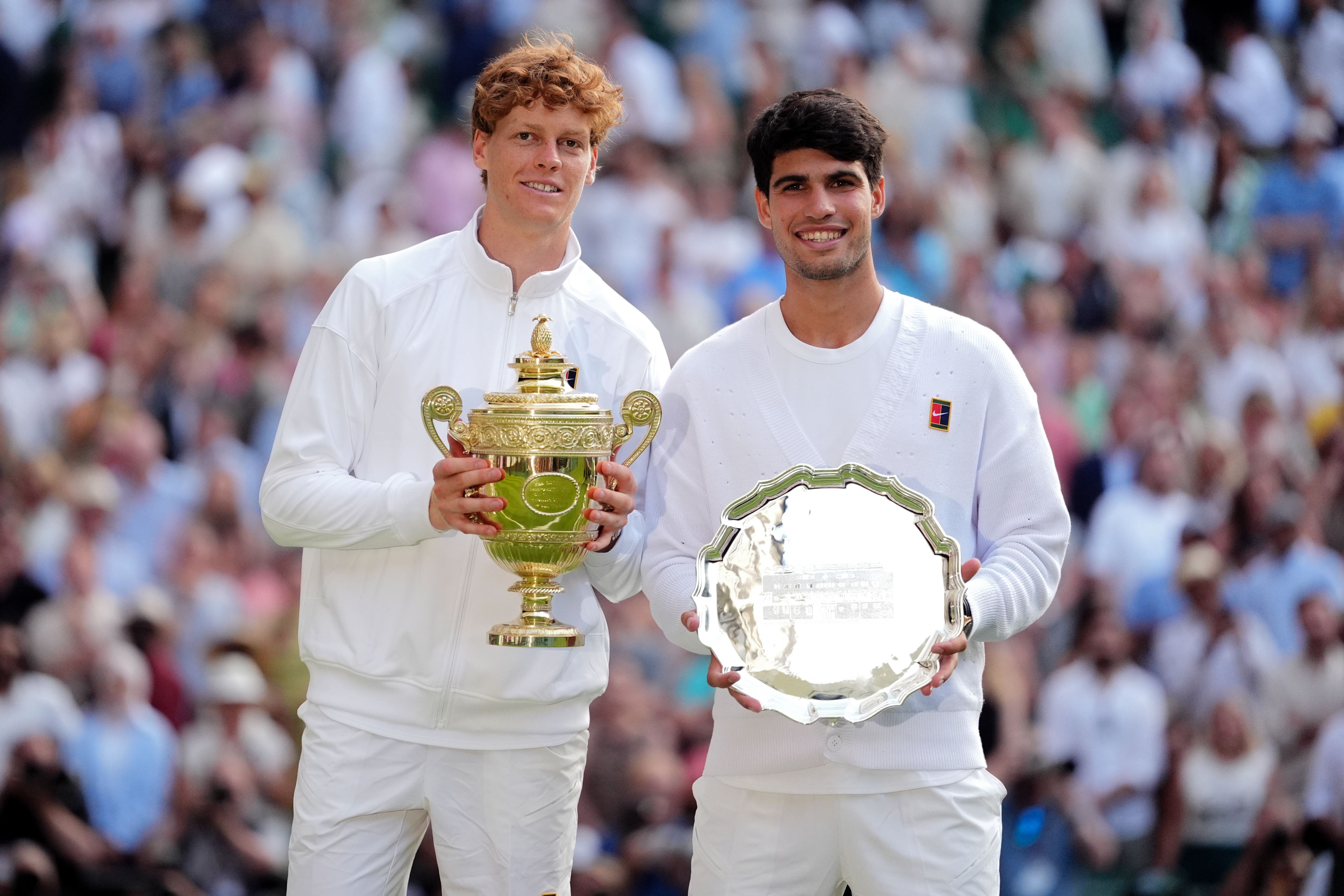 Jannik Sinner, left, and Carlos Alcaraz hold their trophies (Adam Davy/PA)