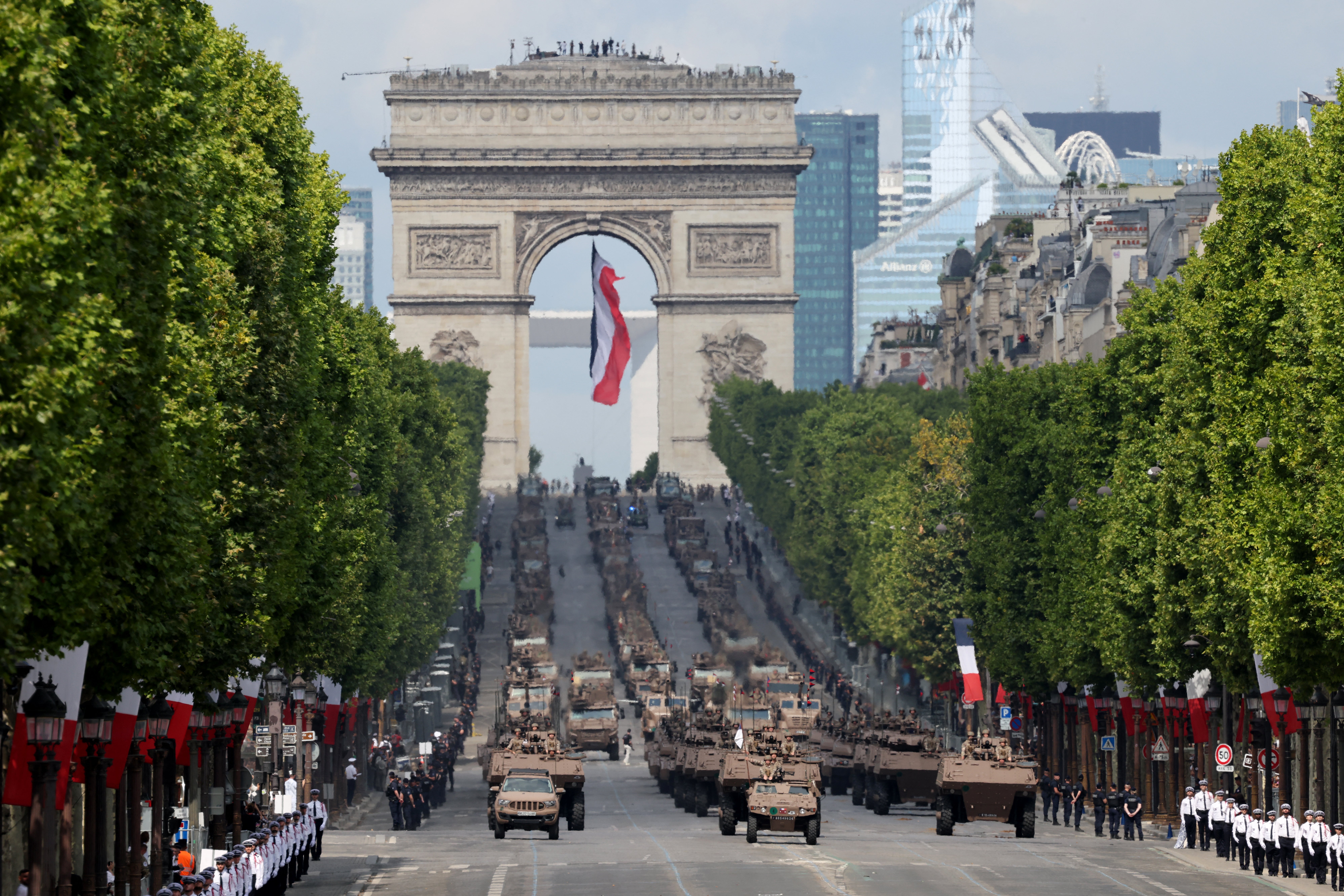 France's 13e Demi-Brigade de Legion Etrangere navigate army vehicles during the military parade