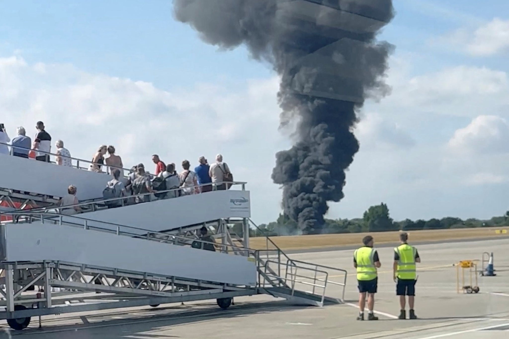 Airport staff watch as the emergency services tackle the blaze