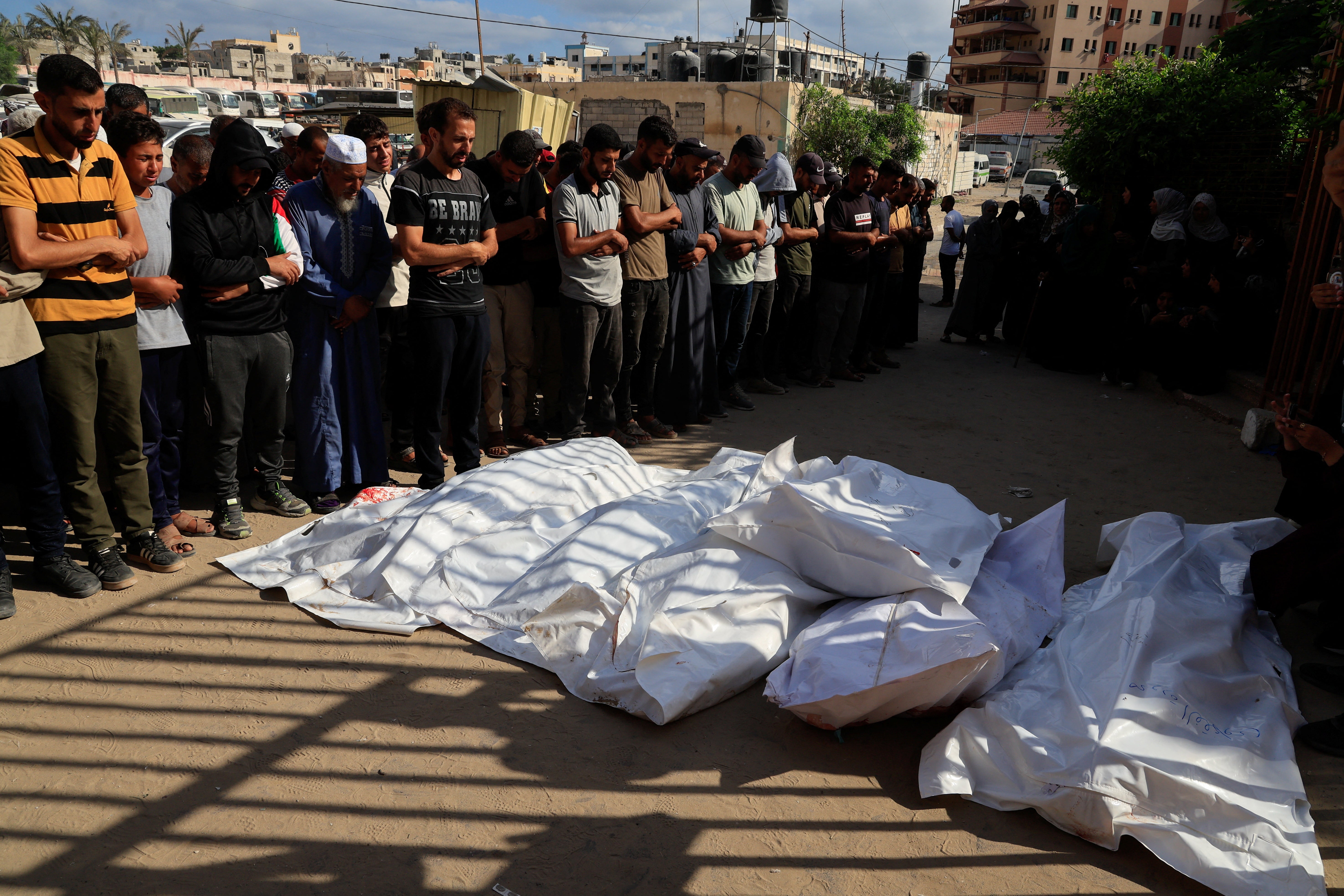 Mourners pray next to the bodies of Palestinians killed in morning Israeli strikes on tents sheltering displaced people