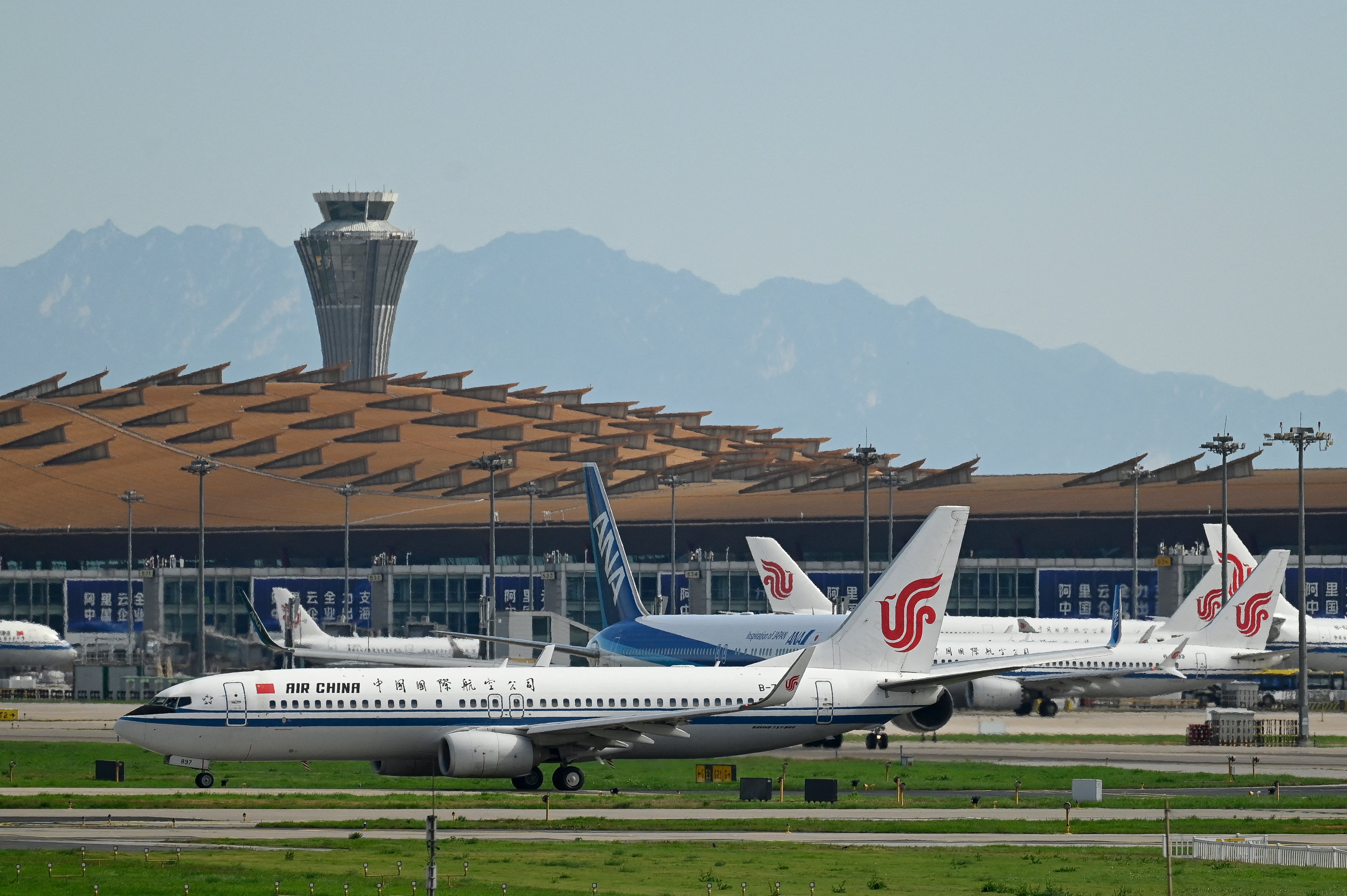 An Air China Boeing 737-800 (front) plane waits to take off at Beijing International airport on 6 July 2025