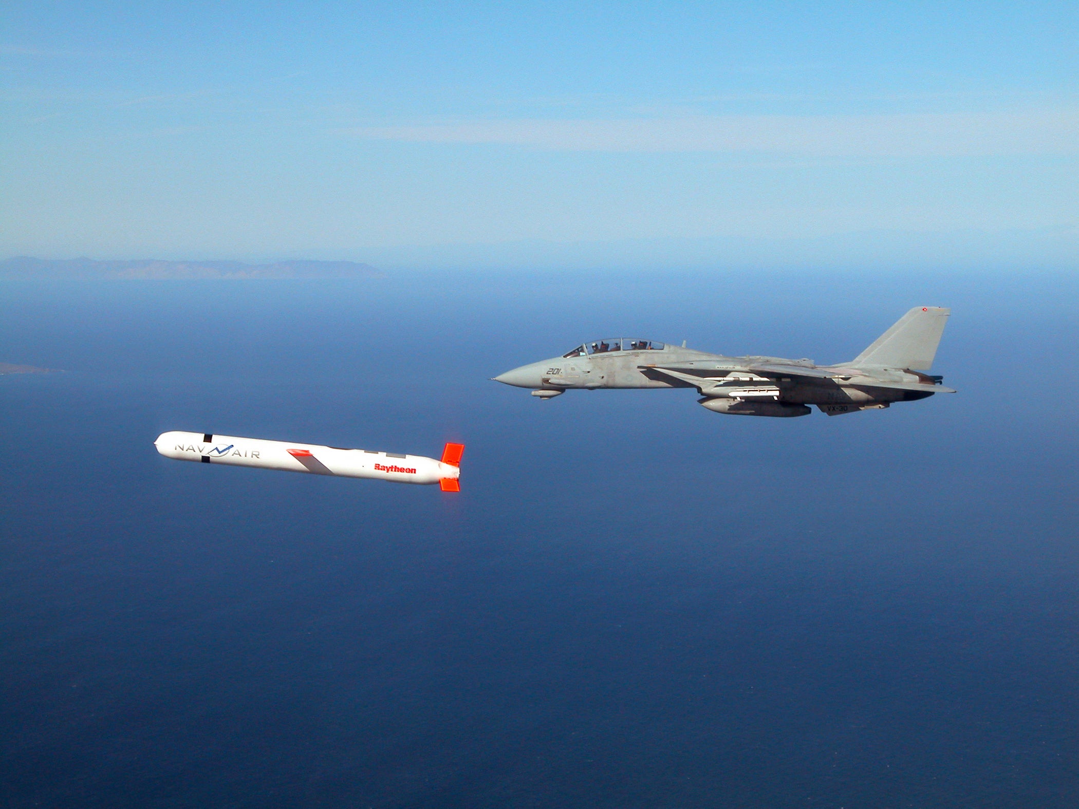 A tactical Block IV cruise missile is escorted by a Navy F-14 fighter during a controlled test in southern California