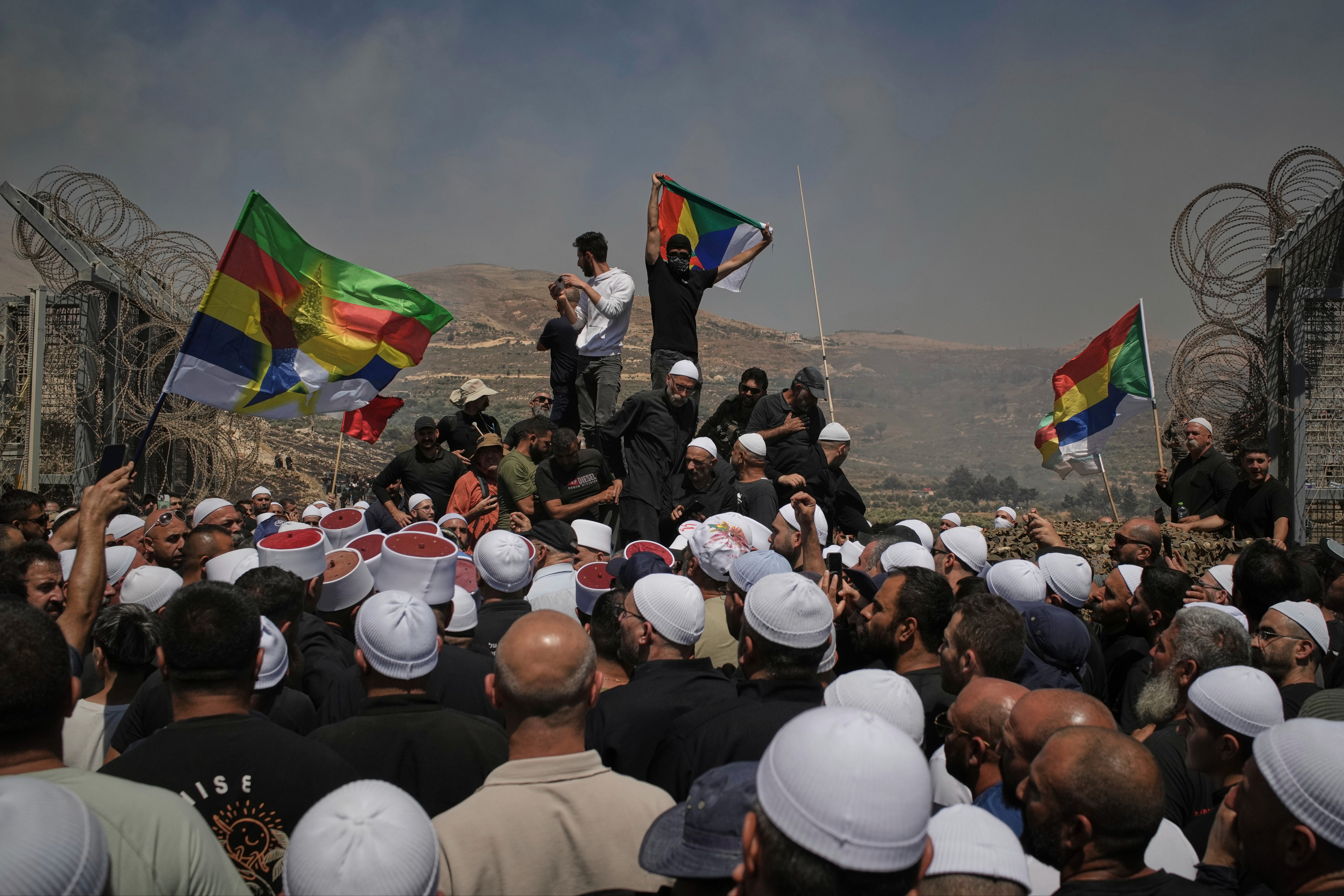 Druze from Syria and Israel protest on the Israeli-Syrian border, in Majdal Shams in the Israeli-controlled Golan Heights, Wednesday, July 16, 2025, amid the ongoing clashes between Syrian government forces and Druze armed groups in the southern Syrian city of Sweida. (AP Photo/Leo Correa)