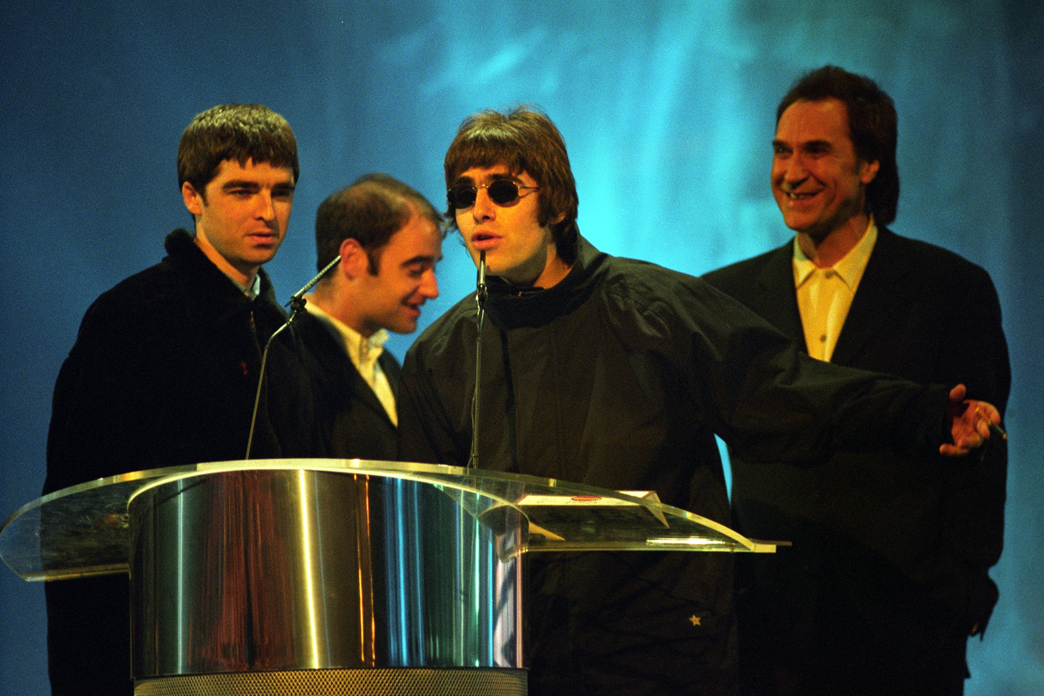 Oasis receive their ‘Best British Newcomer’ award at the 1995 Brits from Kinks lead singer, Ray Davies