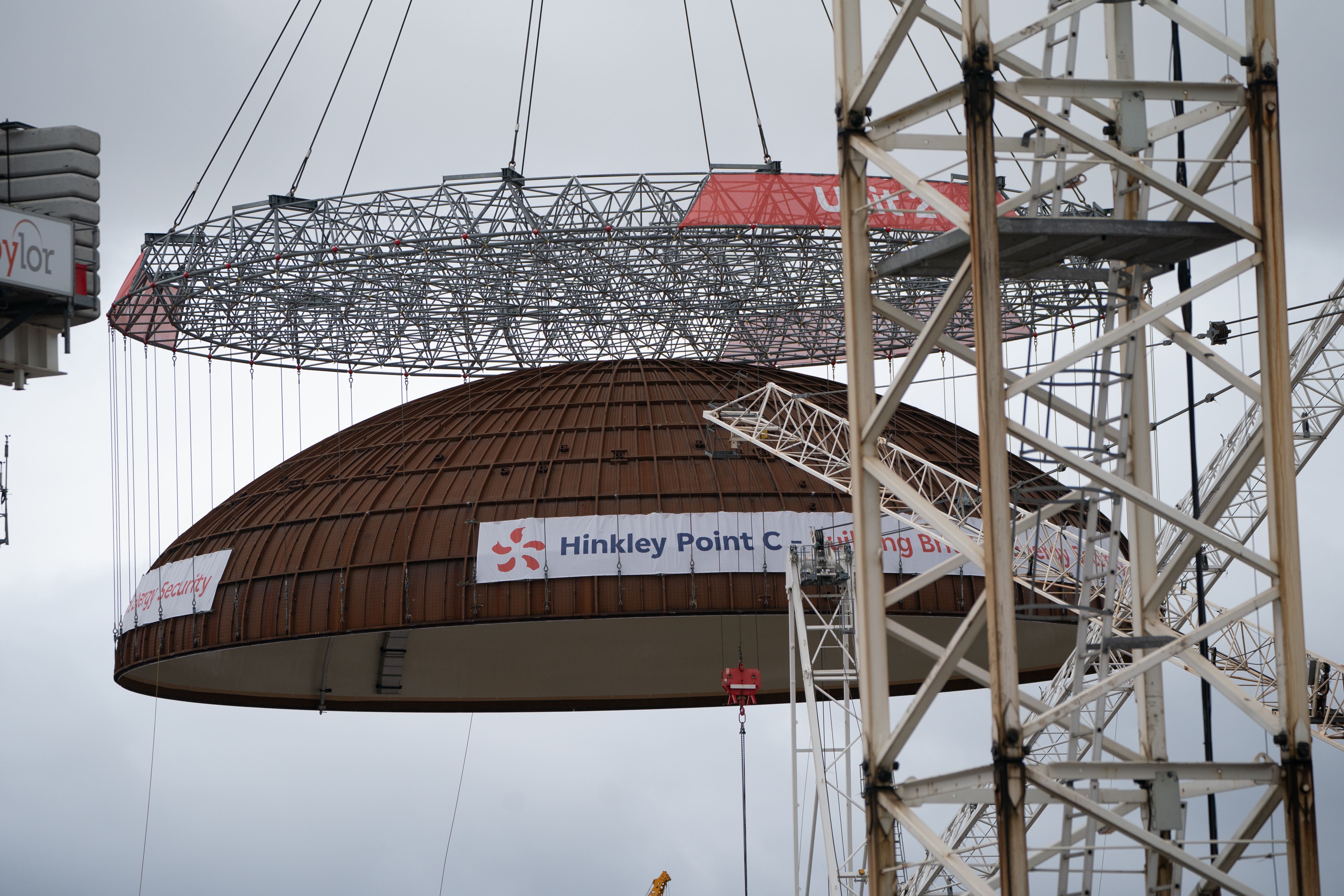Engineering teams use the world’s largest crane – Big Carl – to lift a 245-tonne steel dome onto Hinkley Point C’s second reactor building, at the nuclear power station construction site in Bridgwater, Somerset. The dome closes the building allowing the installation of the nuclear reactor and equipment. Picture date: Thursday July 17, 2025.