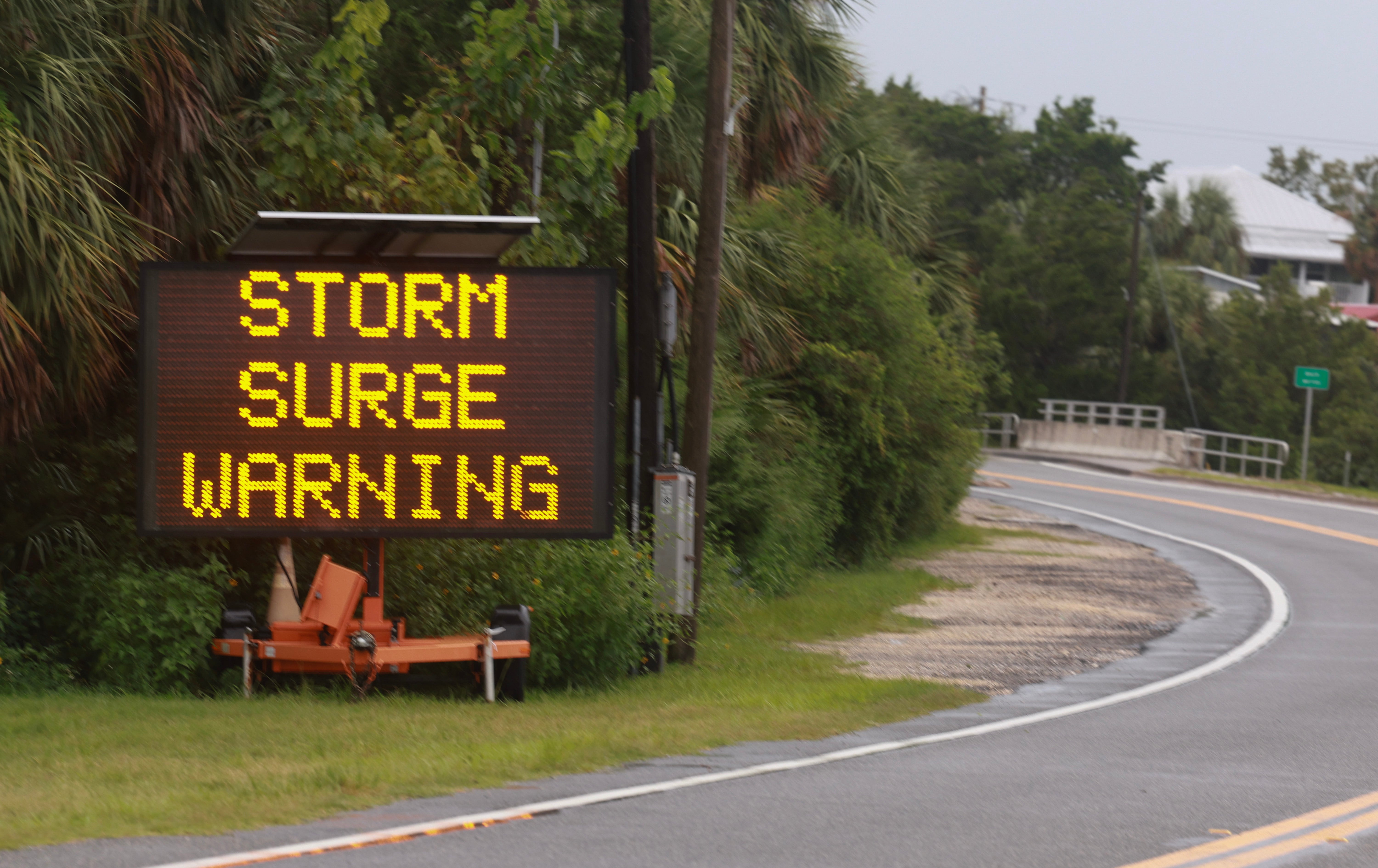 A sign warns of a storm surge before Hurricane Debby last August in Cedar Key, Florida. Vibrio vulnificus ases and deaths reached record levels last year after late-season storms