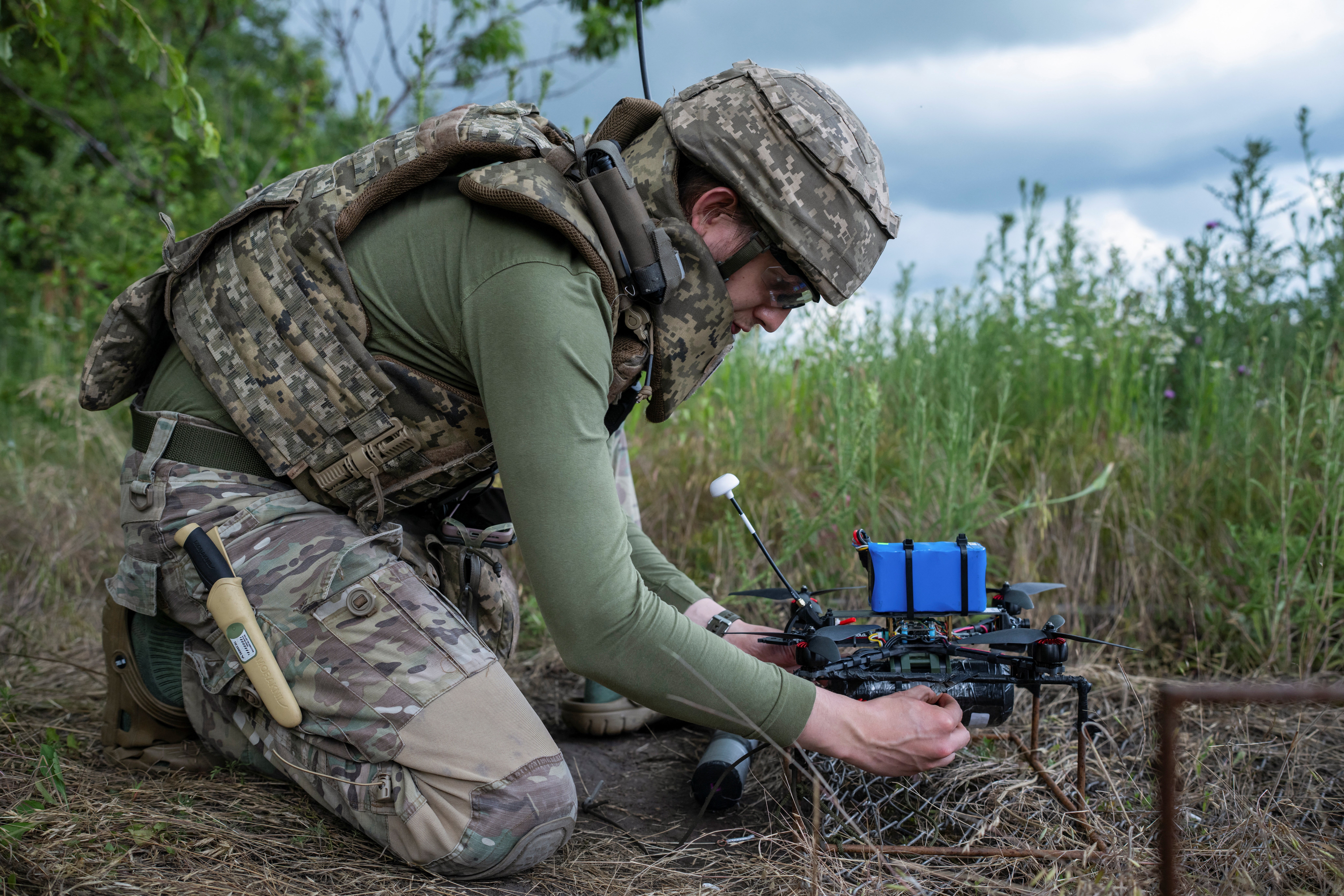 A service member of the 429th Achilles Separate Unmanned Aerial Systems Regiment prepares an FPV-drone for a fly at a position near the front line town of Kupiansk