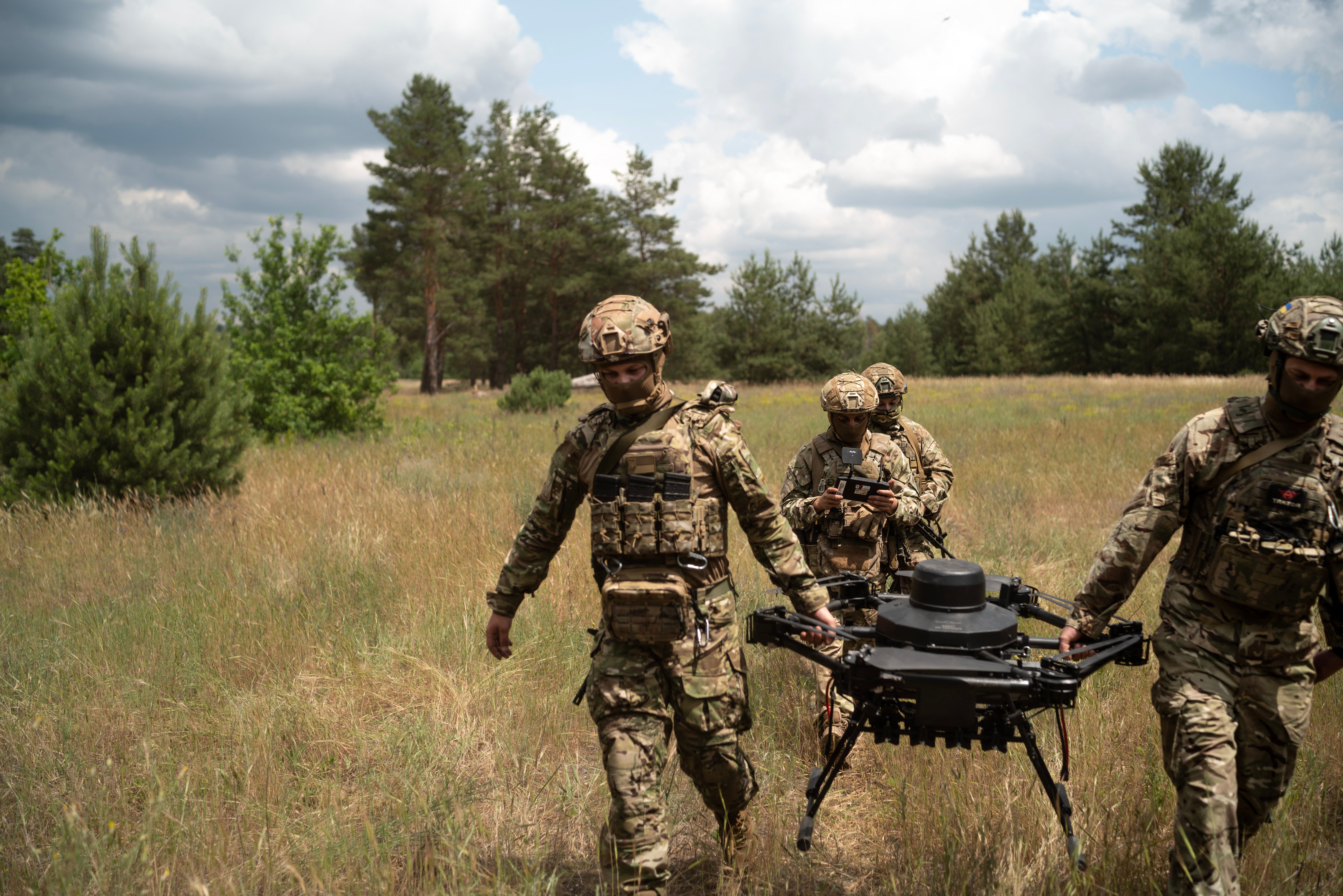 Soldiers from the "Black Sky" battalion of the Spartan brigade carry an agricultural drone, transformed into a front-line delivery cargo