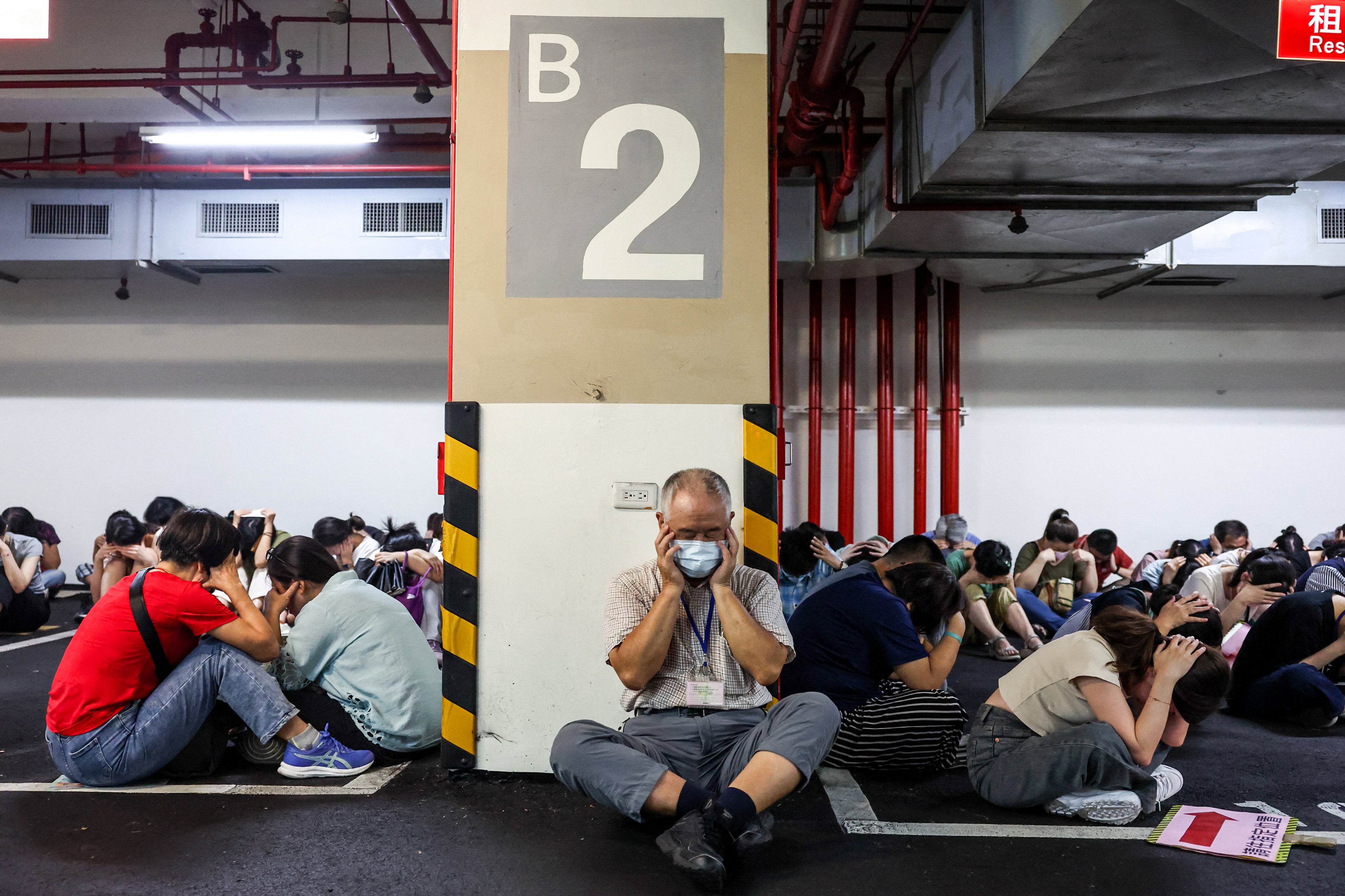 People take shelter during an air raid drill