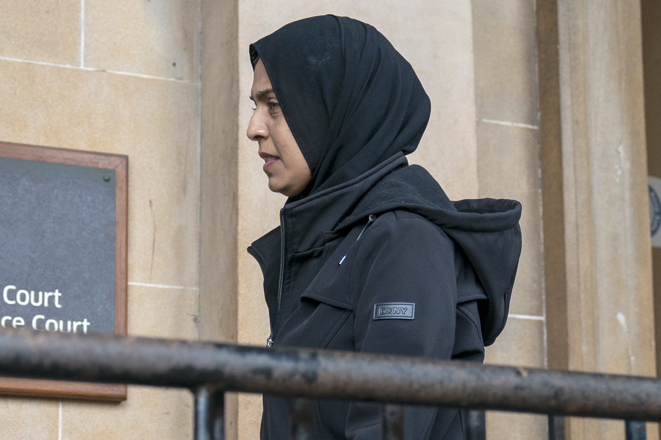 Side view of Attiya Sheikh as she enters court building