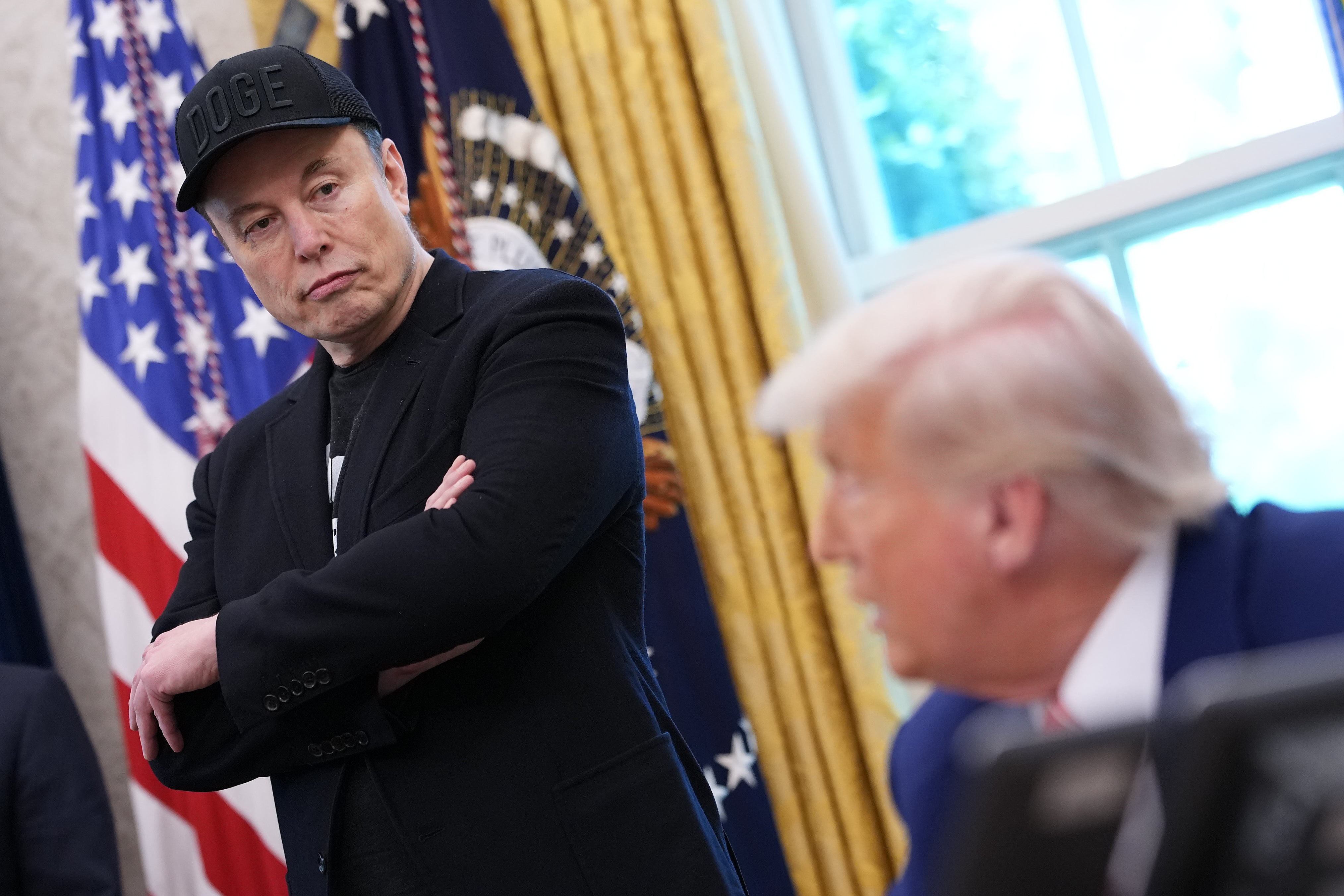 Elon Musk stands in the Oval Office.