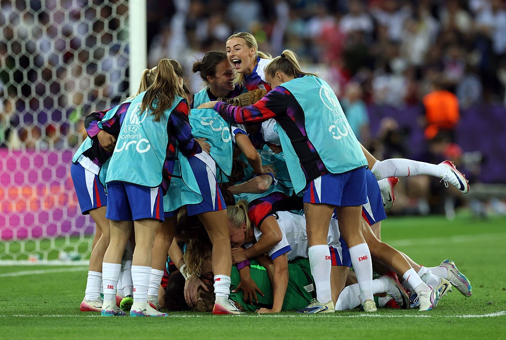 Chloe Kelly celebrates at the top of the pile above goalkeeper Hannah Hampton