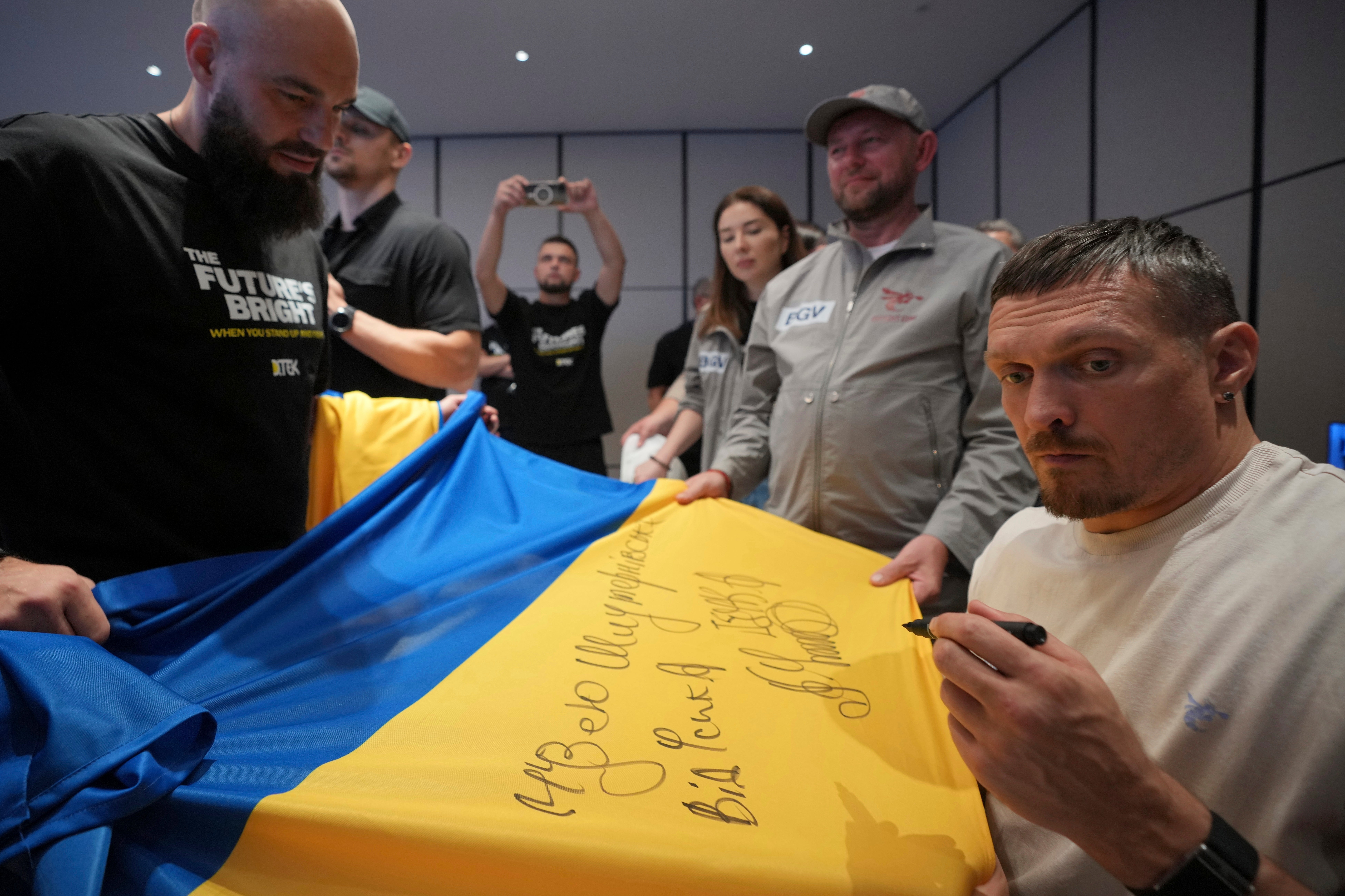 Ukraine's boxer Oleksandr Usyk signs autograph as he meets the Ukrainian war veterans, who are employees of Ukrainian power company DTEK