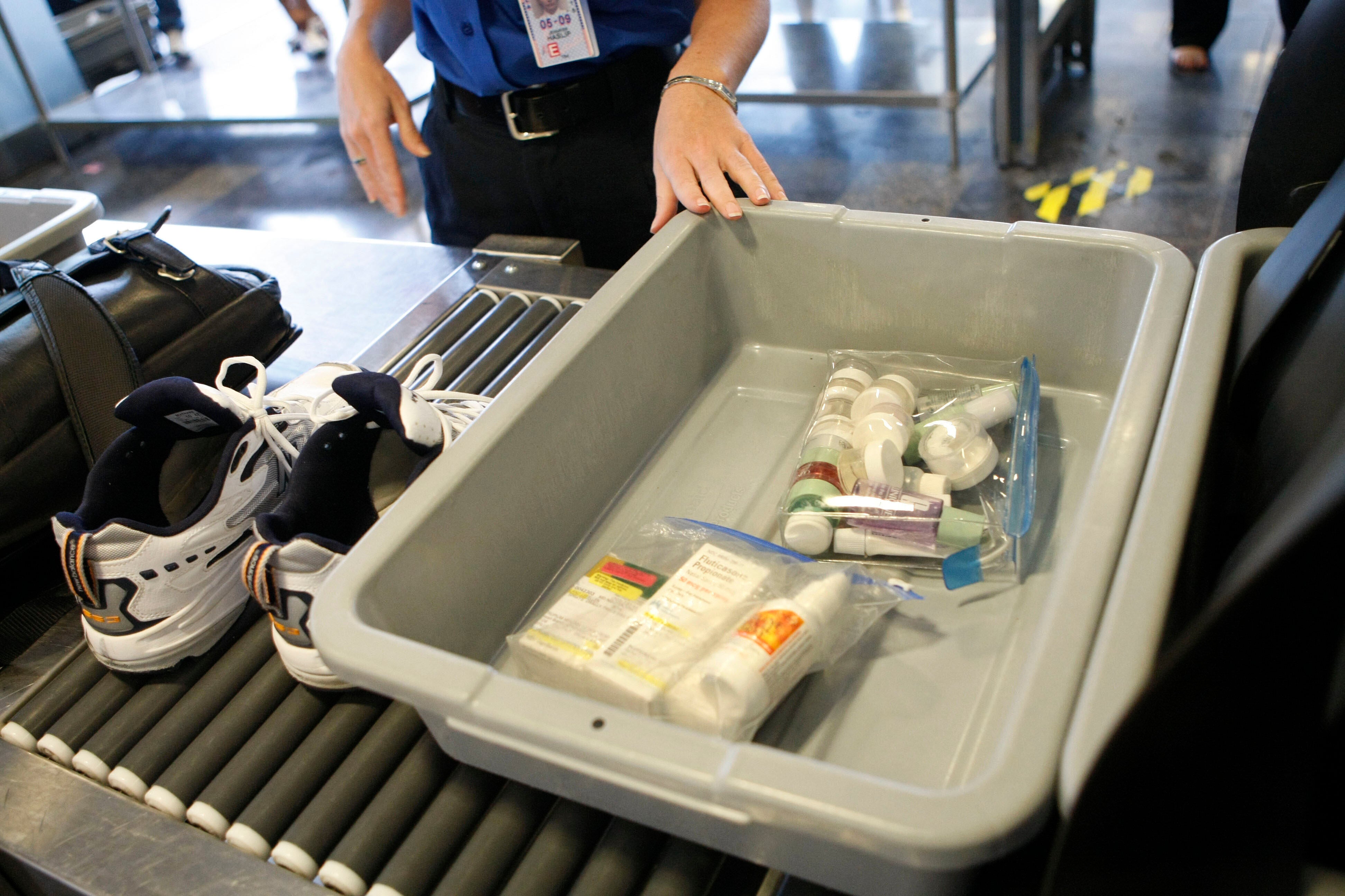 Shoes and small liquid containers are placed in bins to be screened by TSA Supervisor Jennifer Haslip at Washington's Ronald Reagan National Airport