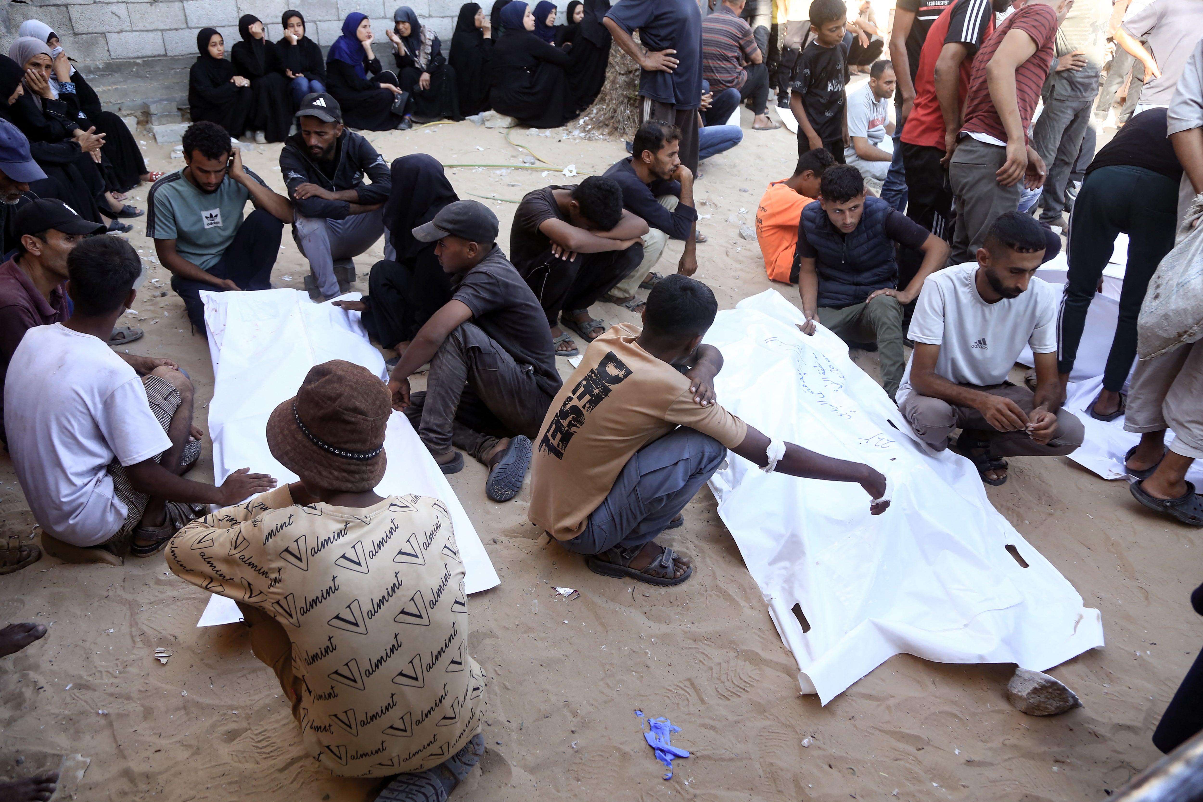 Friends and relatives with two victims of the IDF tank fire in Khan Younis on Saturday