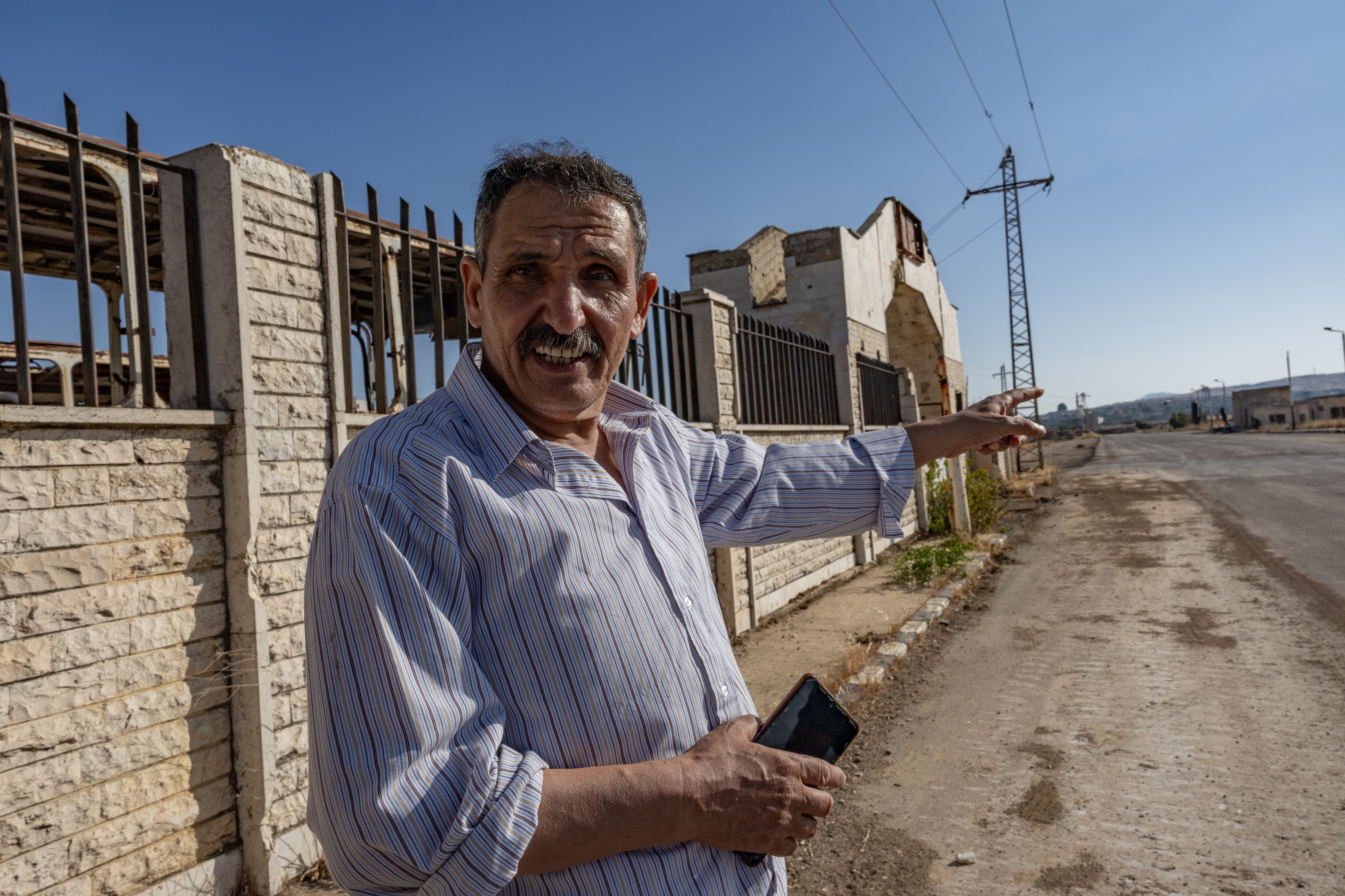 Moussa points at an Israeli sandbank outside Hamidiya town in southern Syria