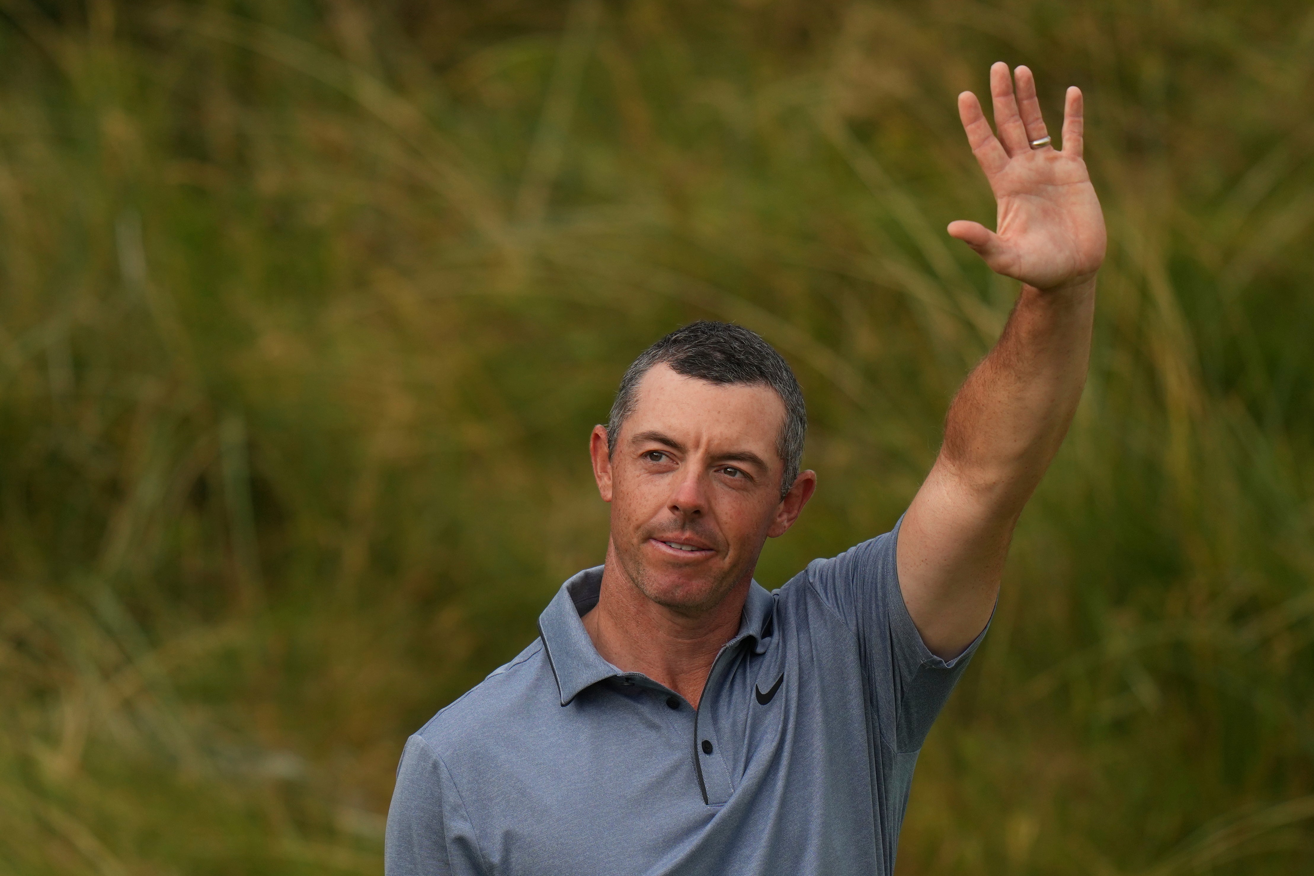 Rory McIlroy of Northern Ireland acknowledges the crowd as he walks onto the 18th green