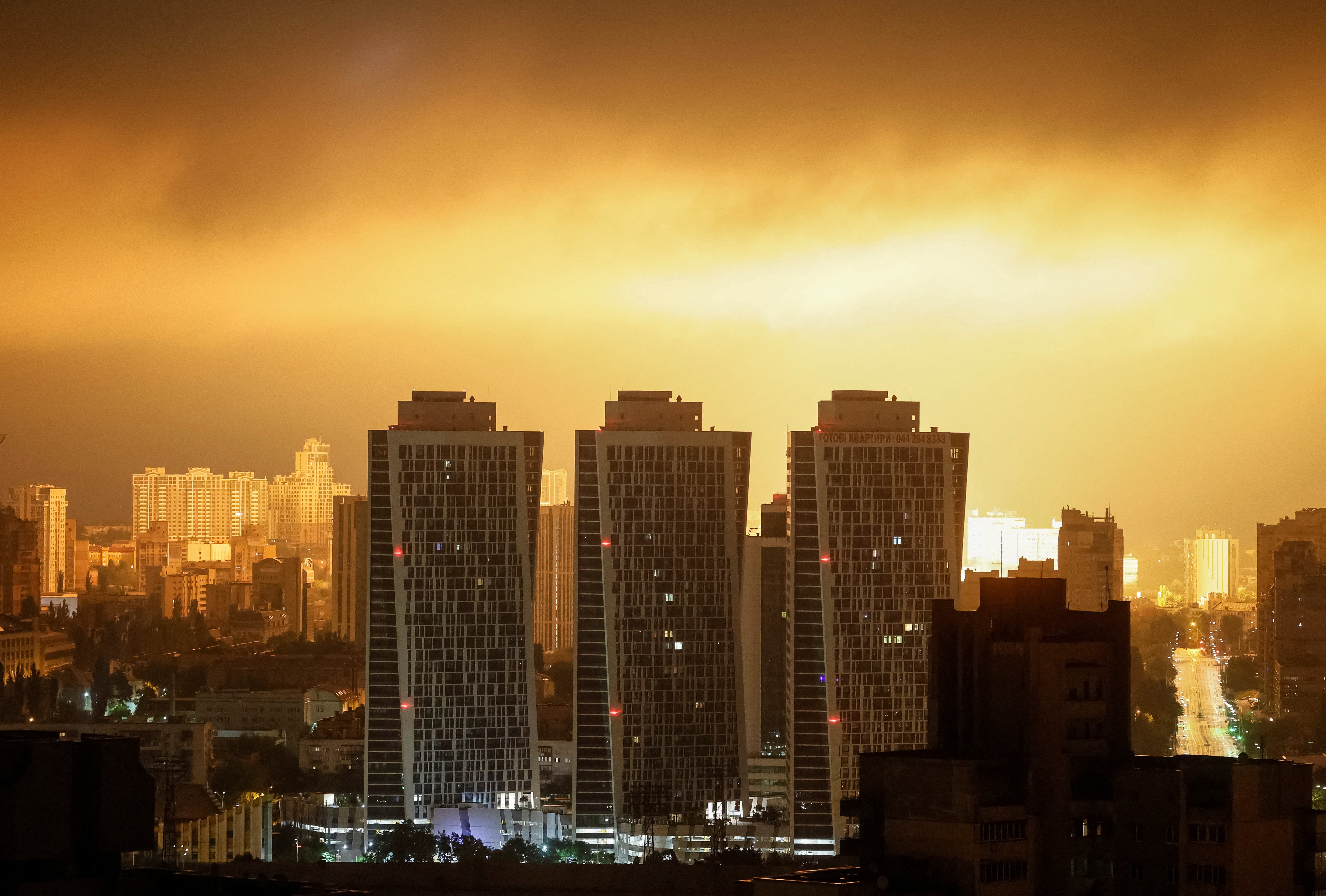 An explosion of a drone lights up the sky over the city during a Russian drone and missile strike