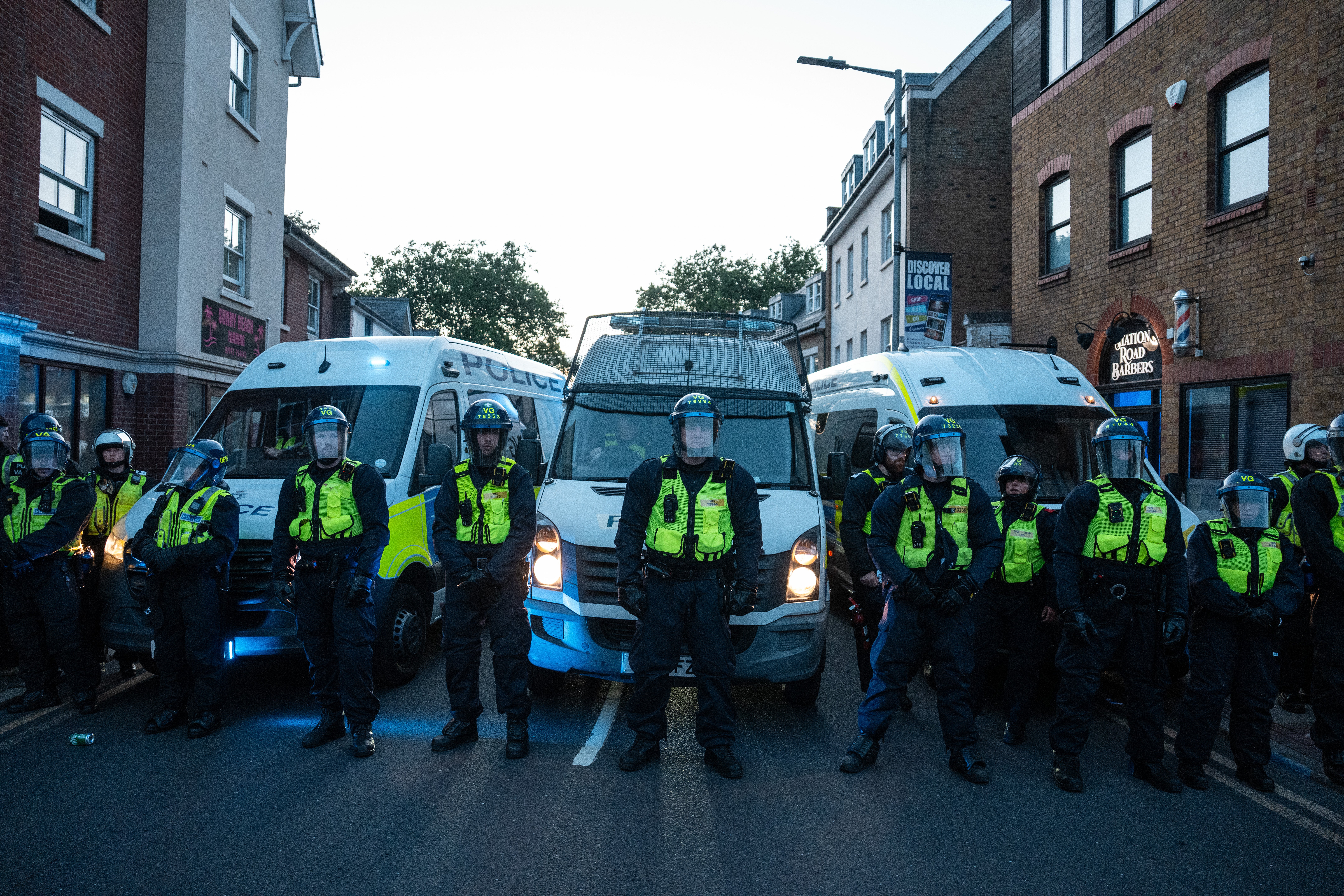 Police officers block a road during a demonstration near the Bell Hotel