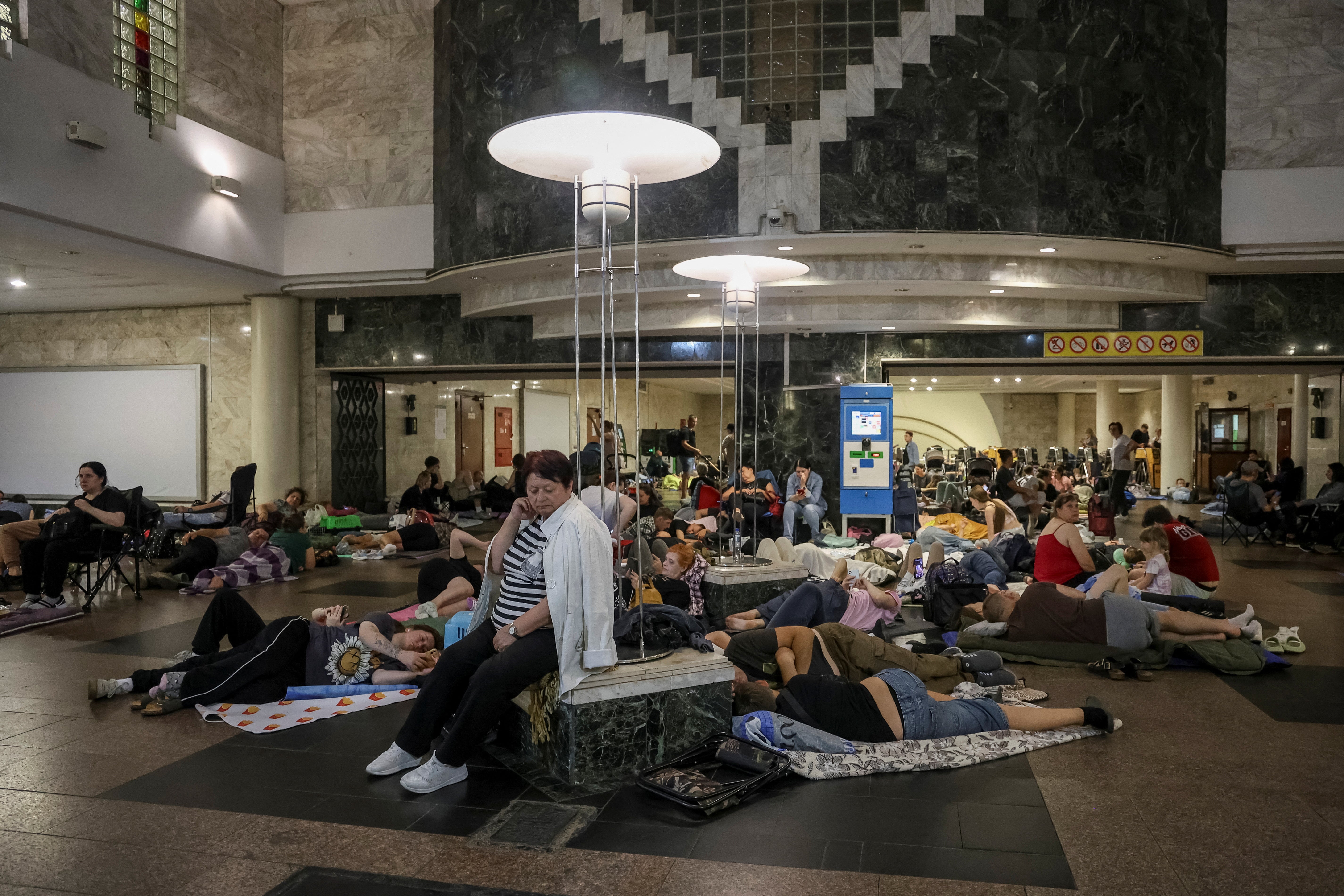 People take shelter inside a metro station during a Russian drone strike