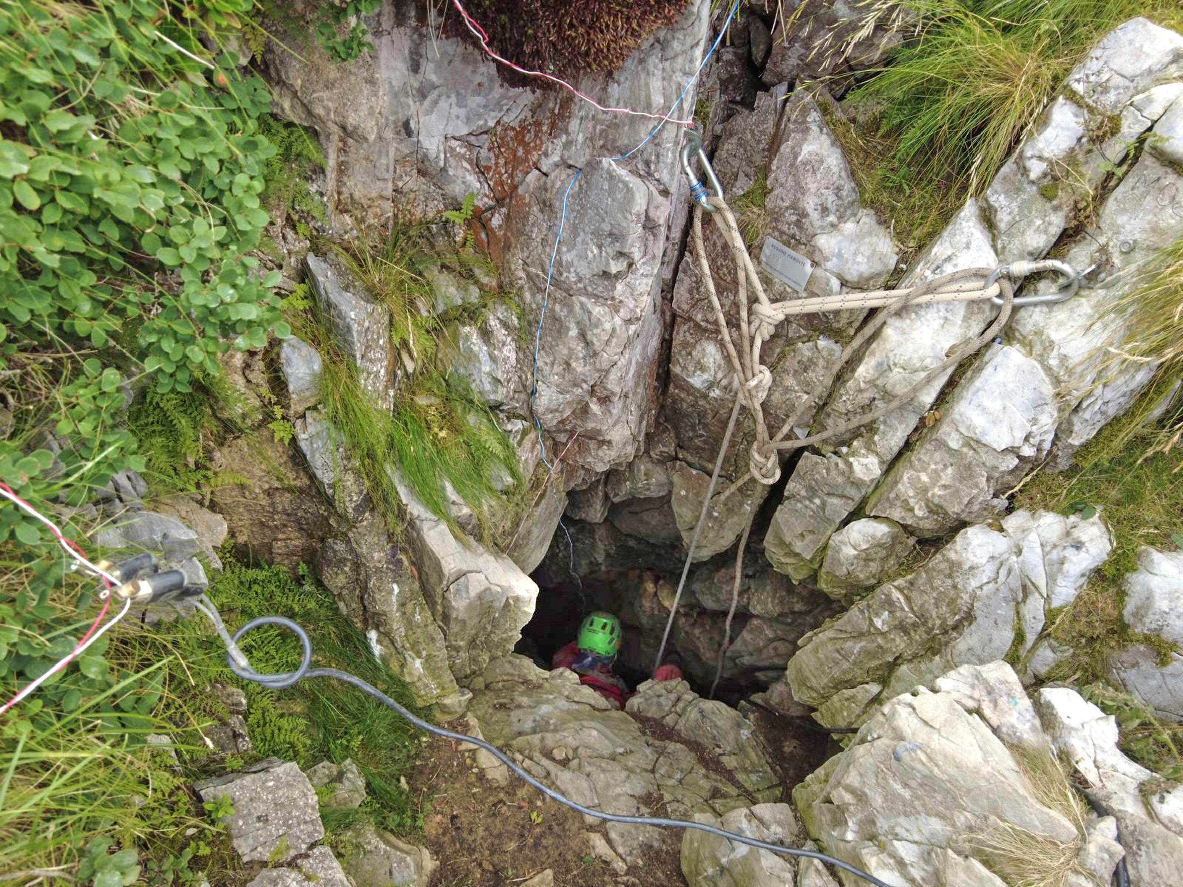A rescuer is lowered into the cave