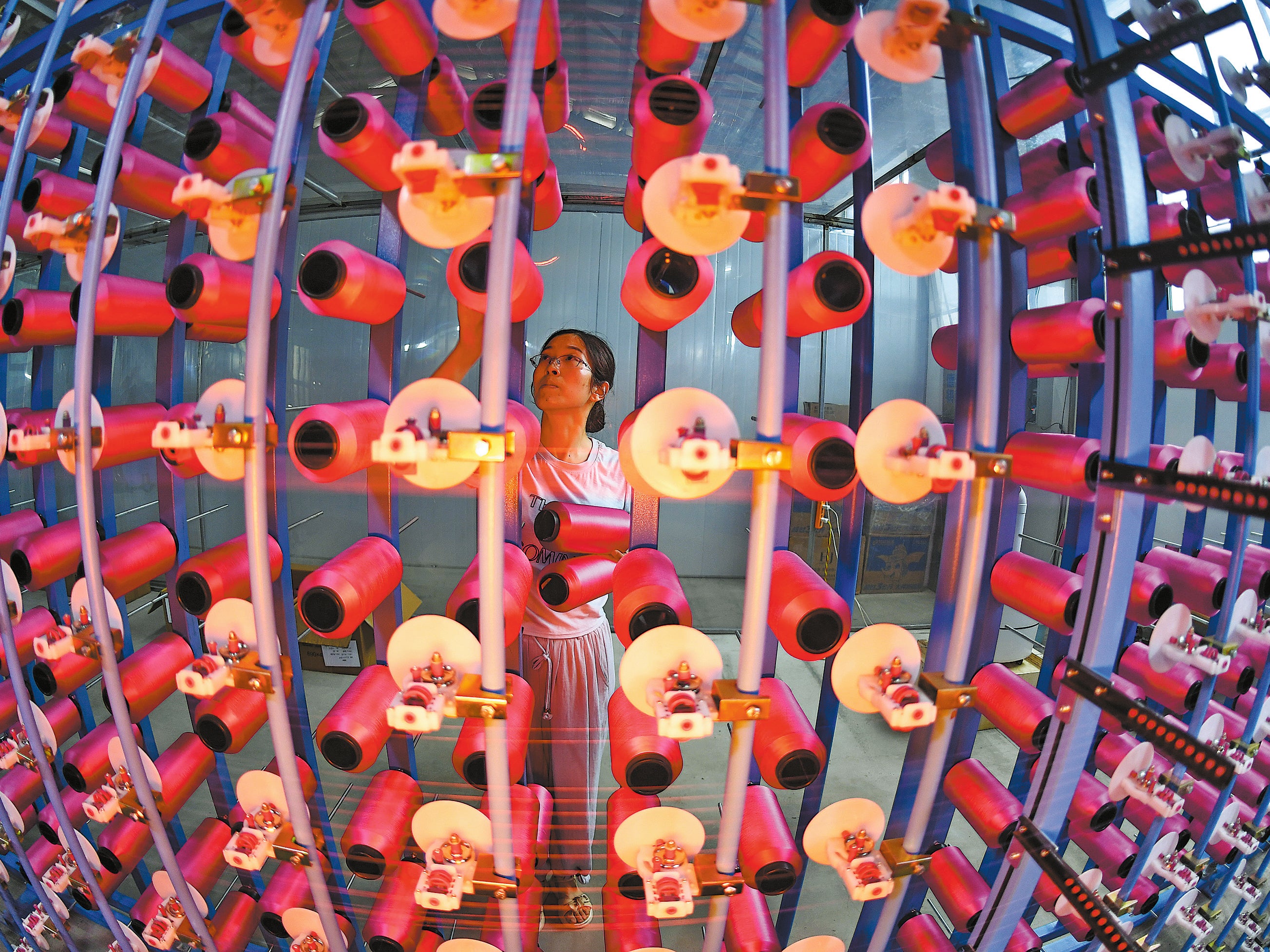 A worker handles products at a brocade workshop in Chengdu, Sichuan province, on 3 July