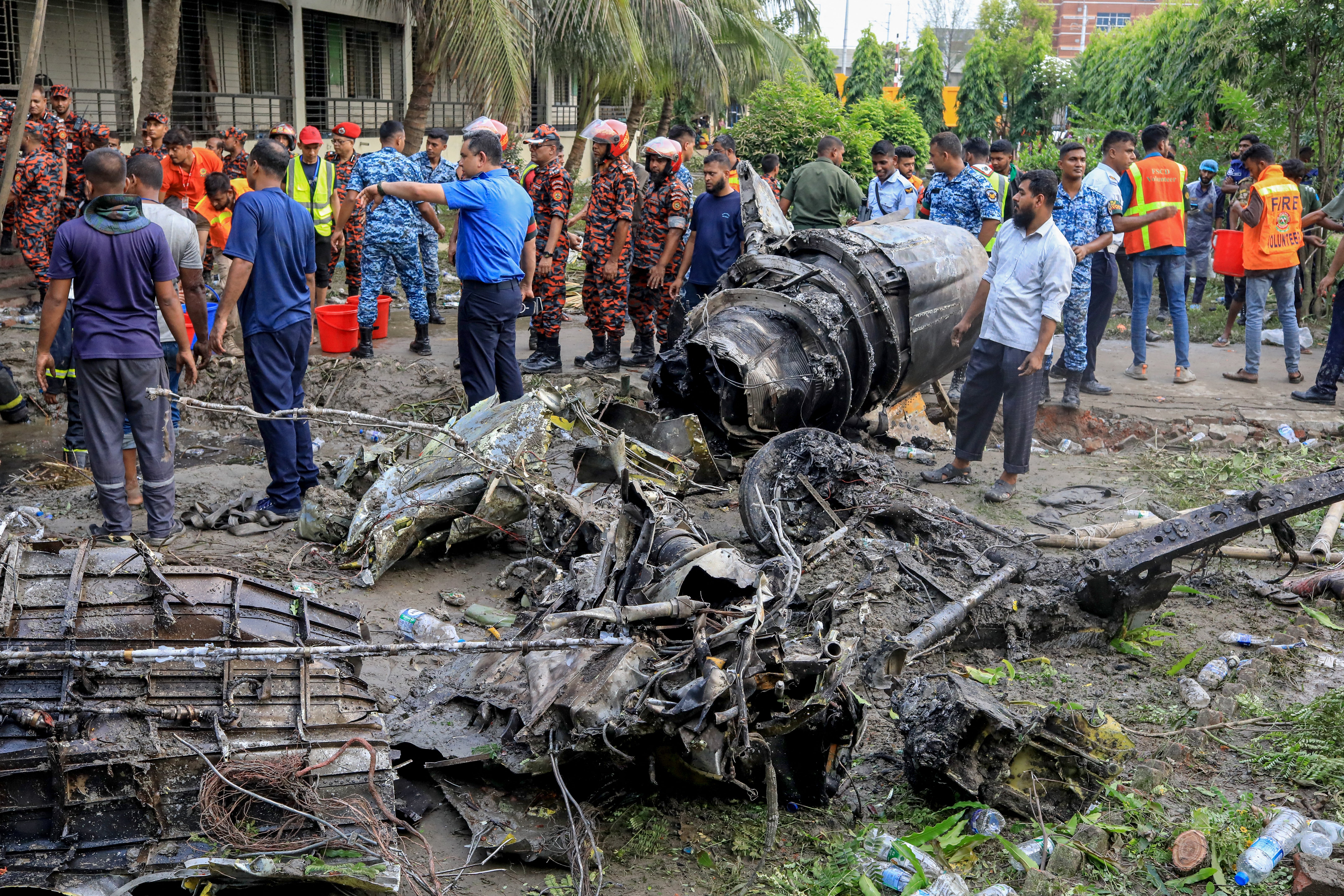 Fire service and security personnel at the site of the aircraft crash in Dhaka on 21 July 2025
