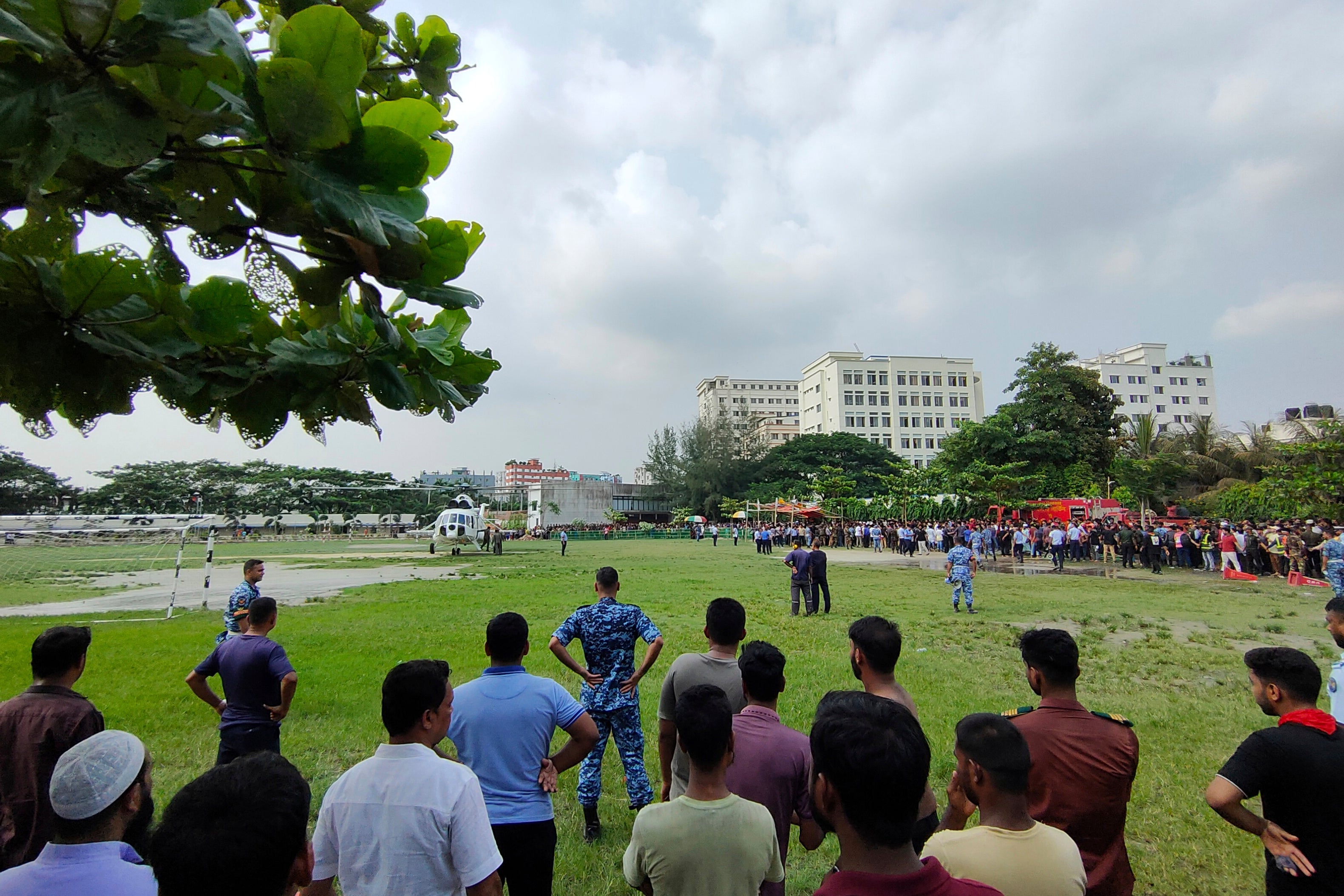 People gather at the site of a Bangladesh Air Force training aircraft crash in Dhaka, Bangladesh, Monday, July 21, 2025. (AP Photo/Mahmud Hossain Opu)
