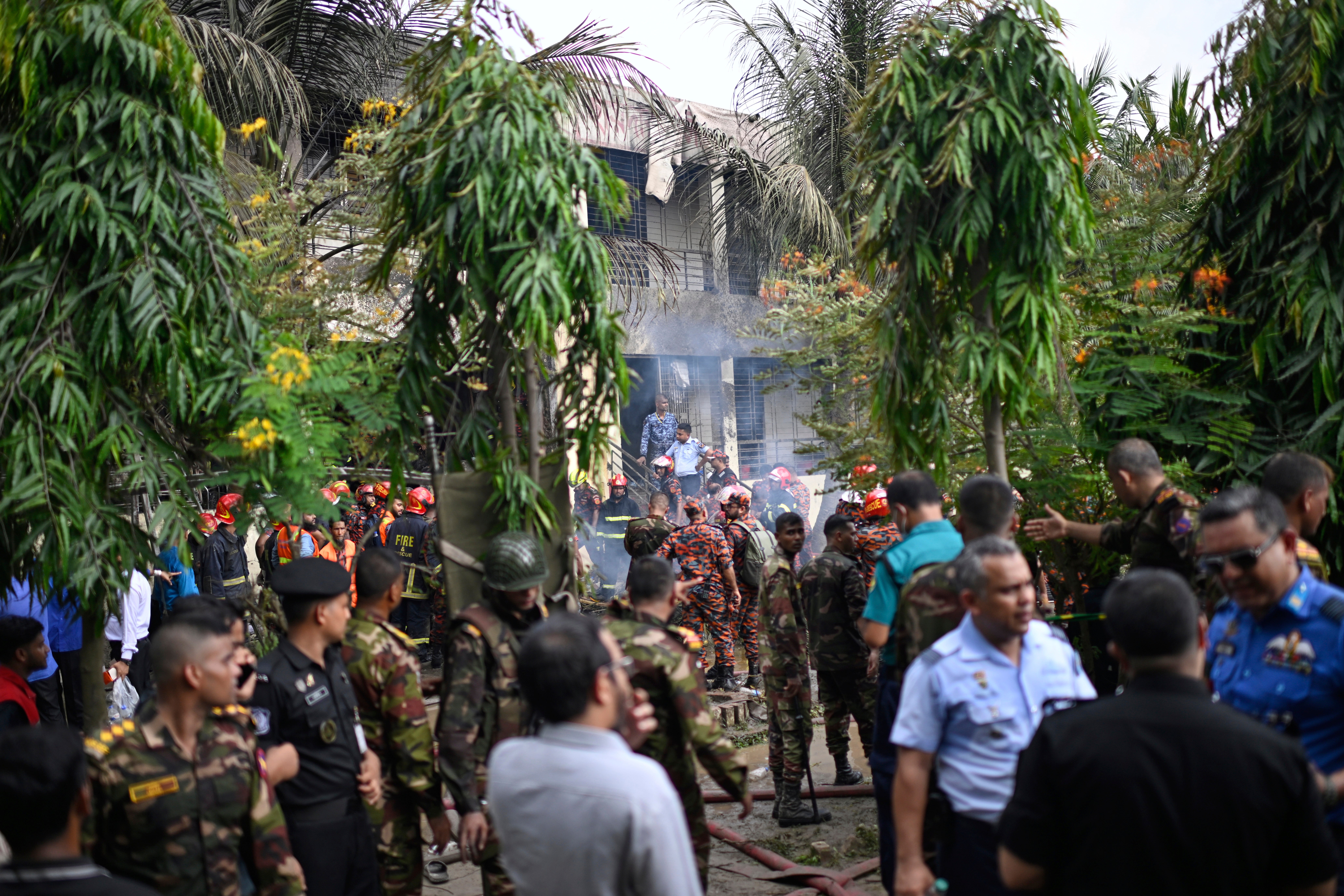 Firemen and security personnel look for the survivors after a Bangladesh Air Force training aircraft crashed into a school campus shortly after takeoff in Dhaka, Bangladesh, Monday, July 21, 2025. (AP Photo/Mahmud Hossain Opu)