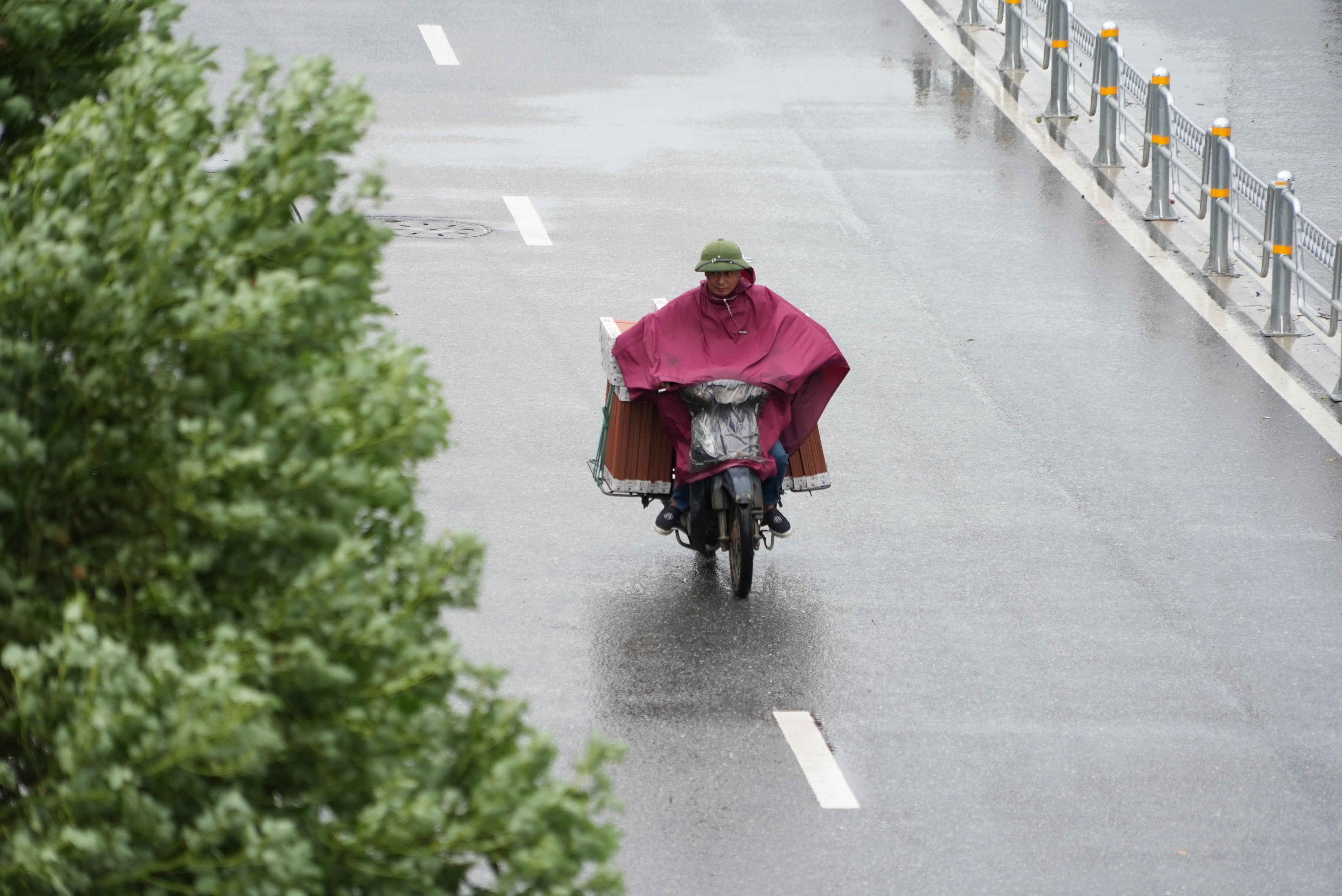 A mperson on a motocycle amid rains brought by tropical storm Wipha