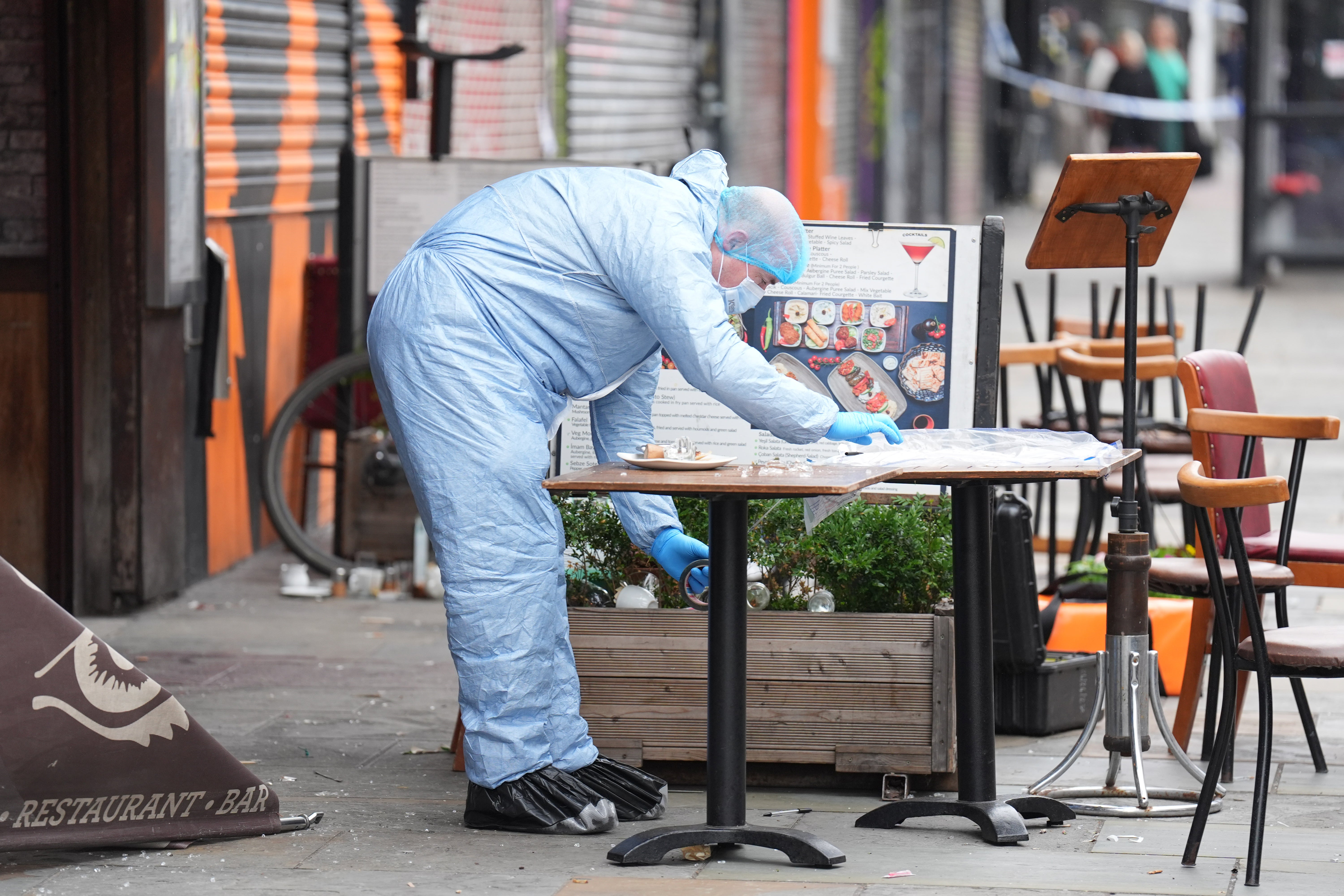 A police forensic officer at the scene of a shooting at Kingsland High Street