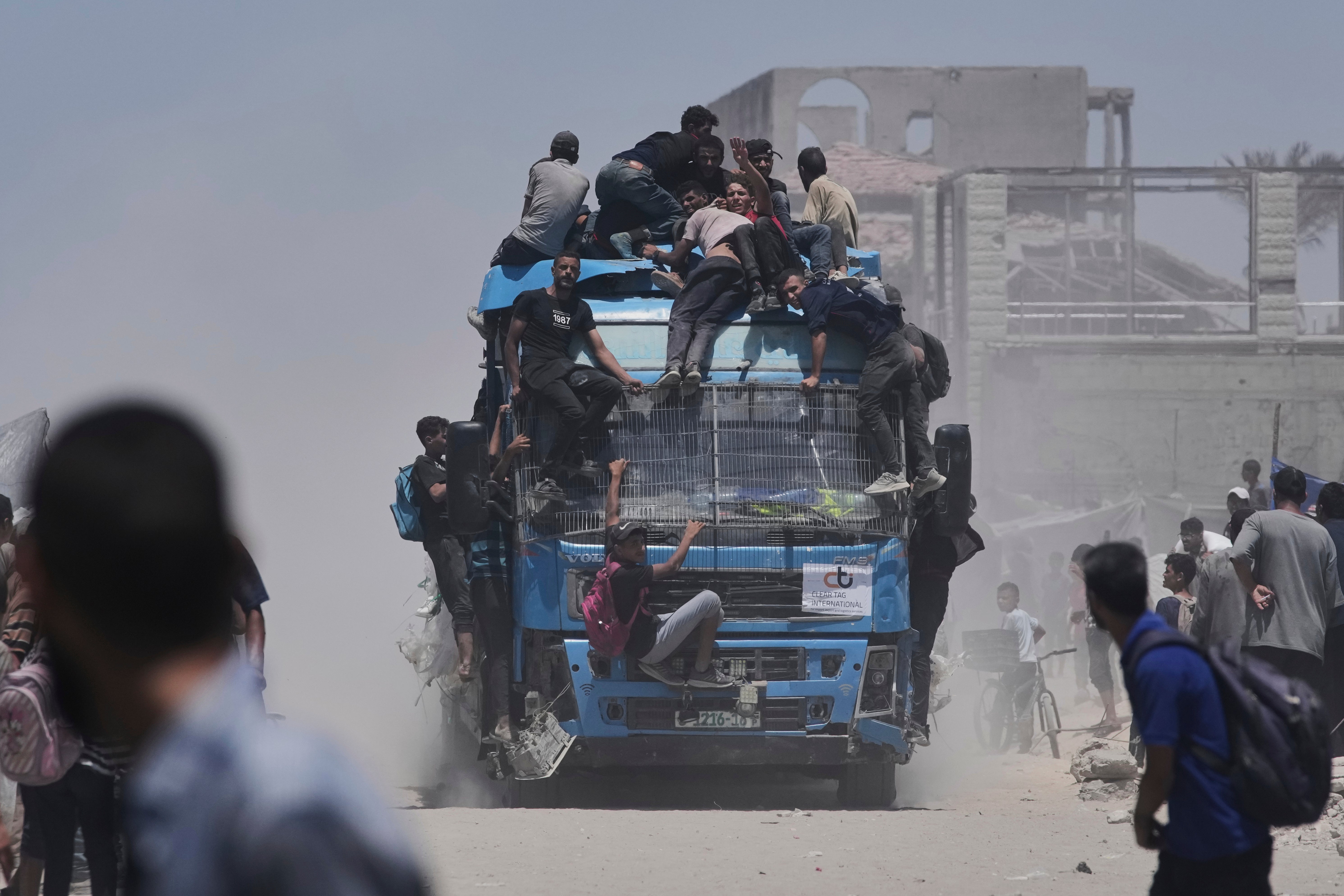 Palestinians hold onto an aid truck returning to Gaza City