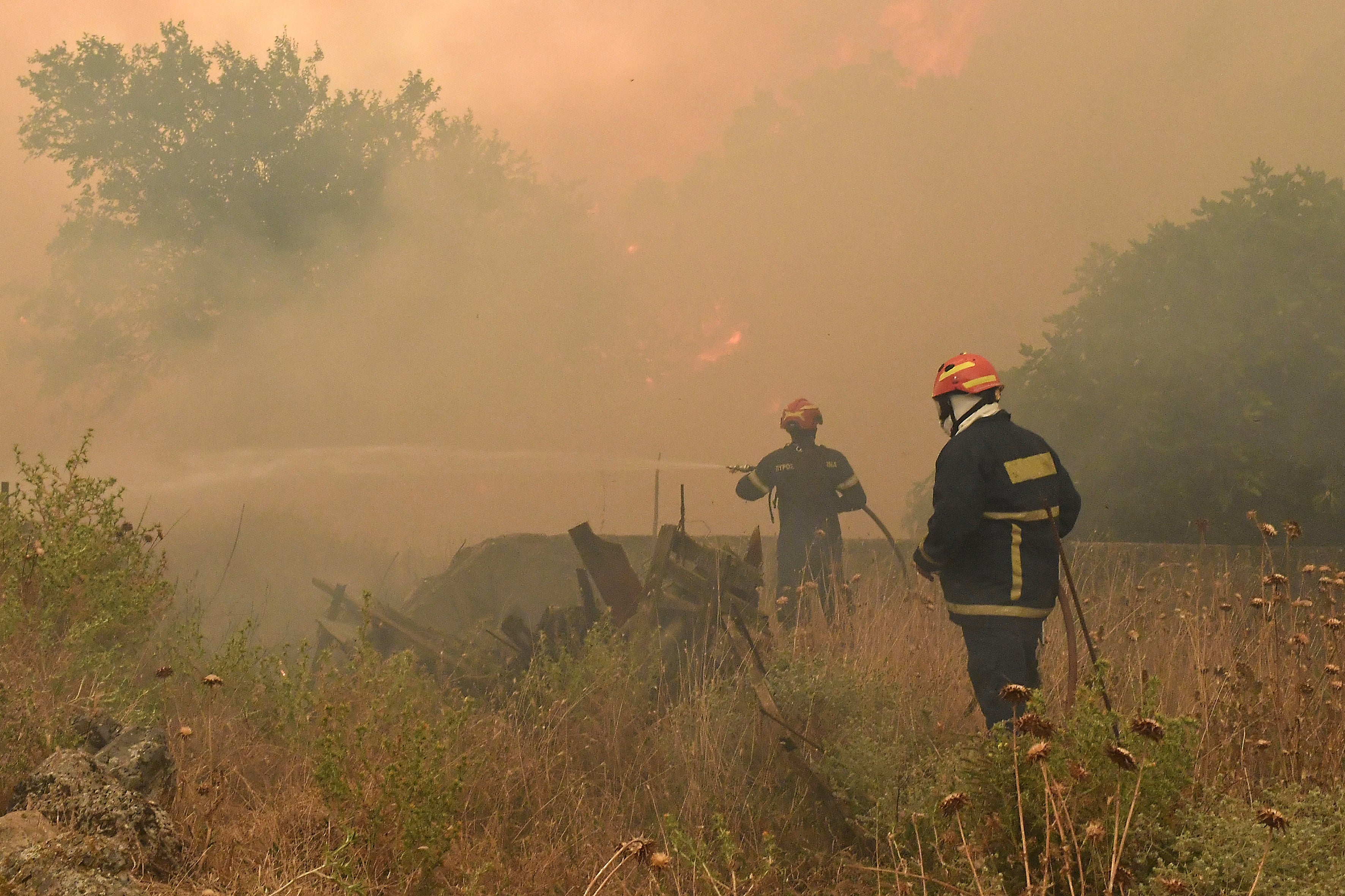 Firefighters try to extinguish a major forest fire in the village of Karteri, near Corinth, west of Athens, Greece, on Tuesday, July 22, 2025. (AP Photo/Vasilis Psomas)