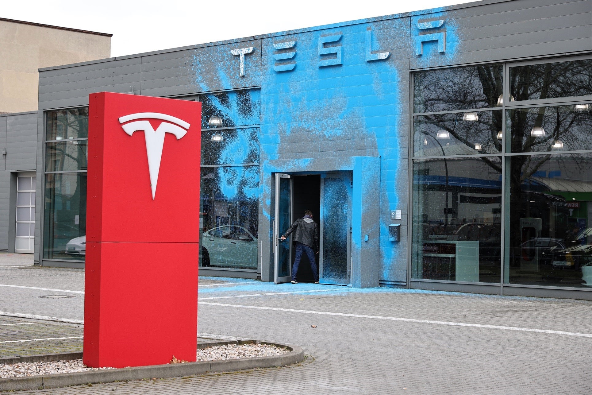 A Tesla car dealership stands doused in blue paint following vandalism by activists of the group New Generation on 31 March, 2025 in Berlin, Germany
