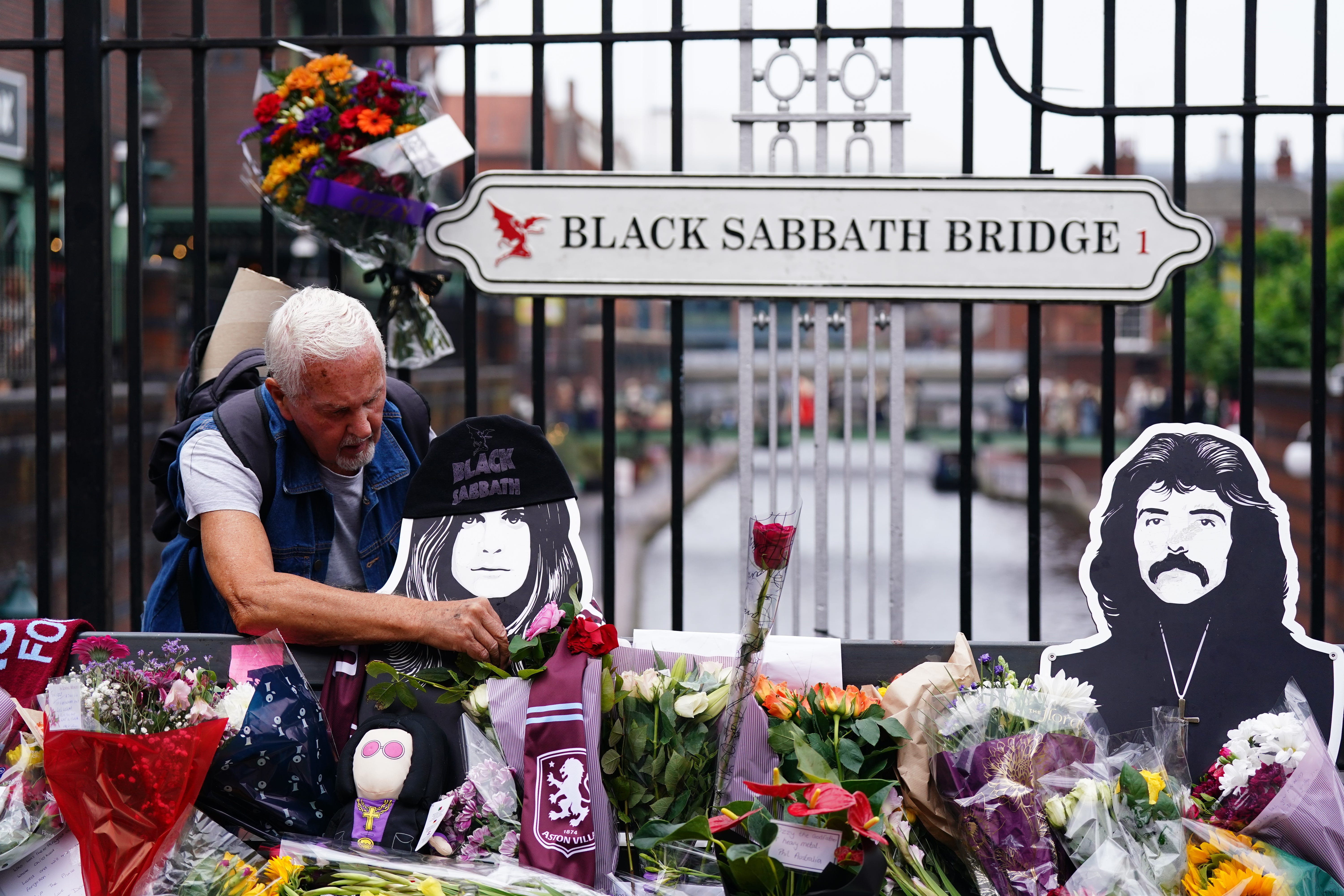 Floral tributes are left on the Black Sabbath Bridge bench on Broad Street in Birmingham (Jacob King/PA)