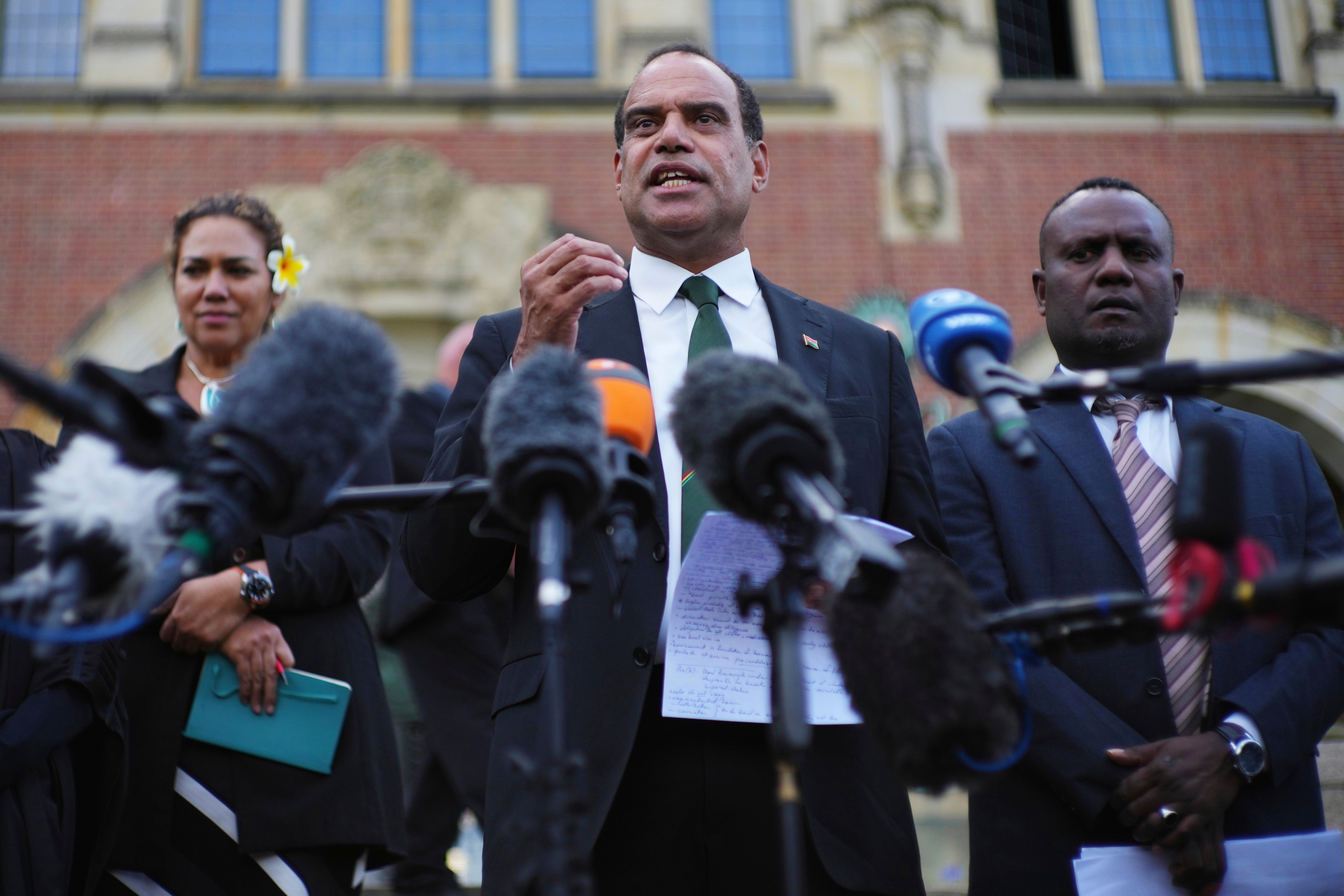 Ralph Regenvanu, center, Vanuatu's minister for climate change, speaks after the International Court of Justice's advisory opinion about nations' obligations to tackle climate change and consequences they may face if they don't in The Hague, Netherlands