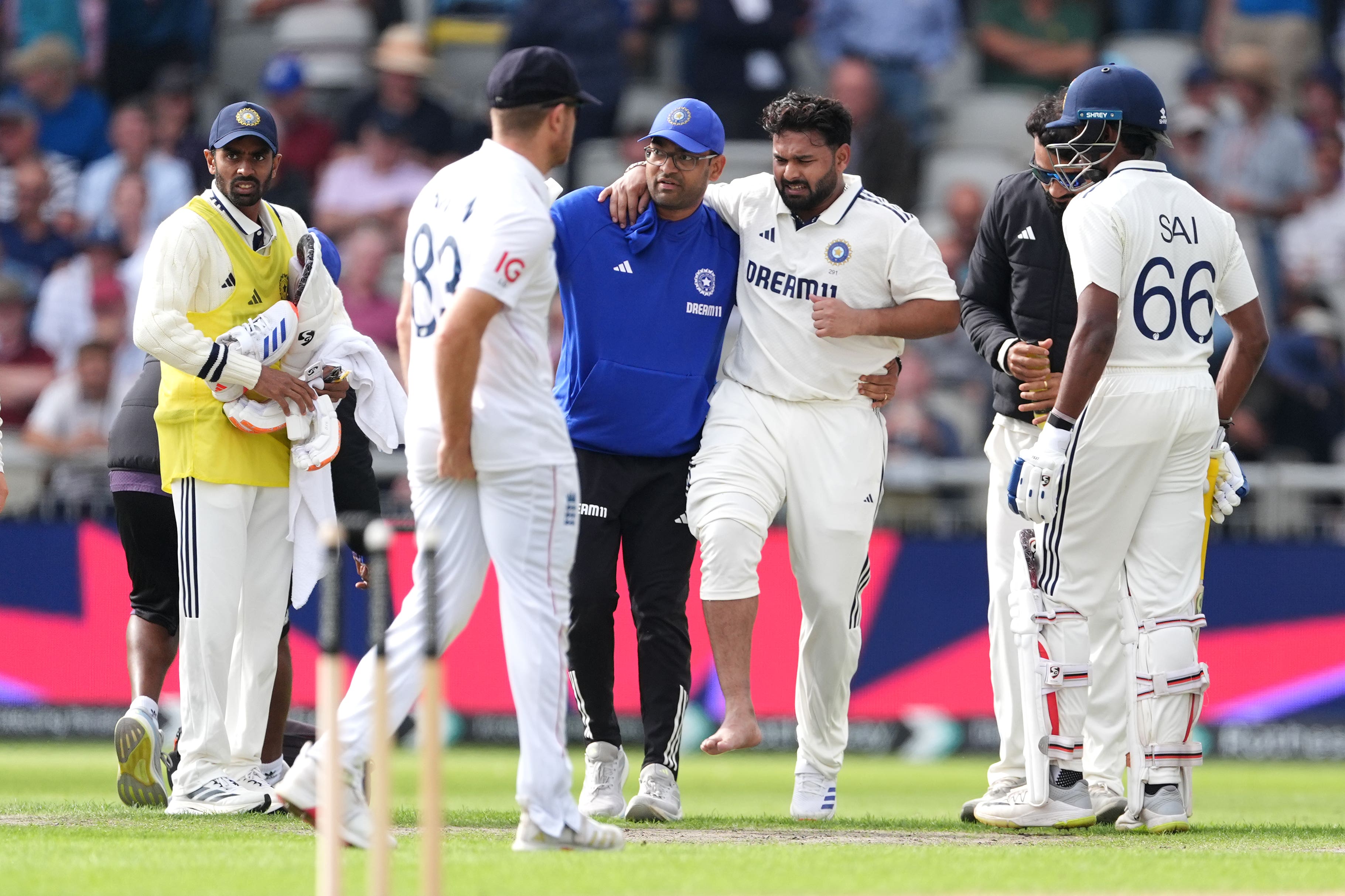Rishabh Pant (centre right) is helped off the field (Martin Rickett/PA)