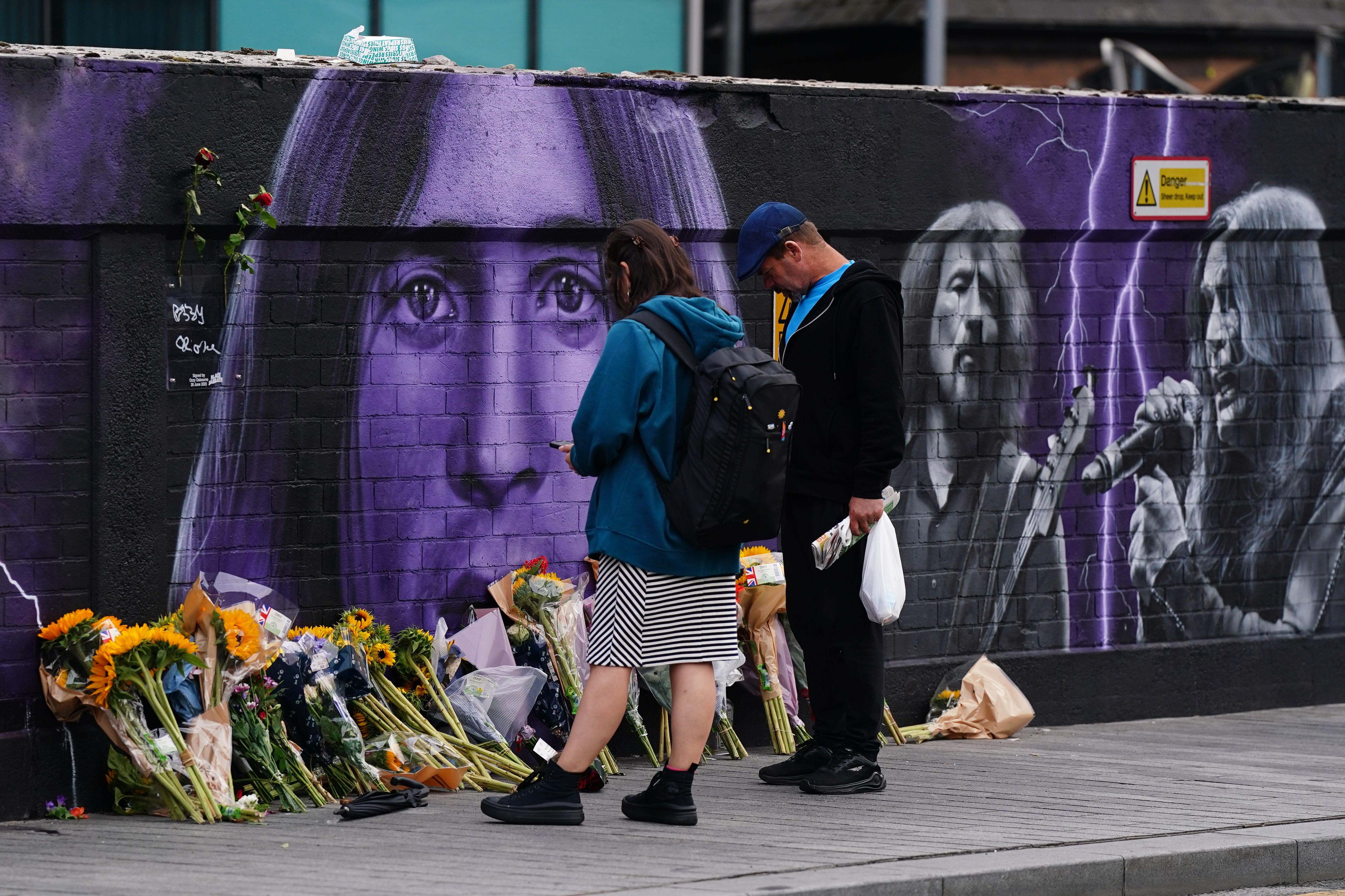 Mourners leave flowers at the Black Sabbath memorial on Navigation Street