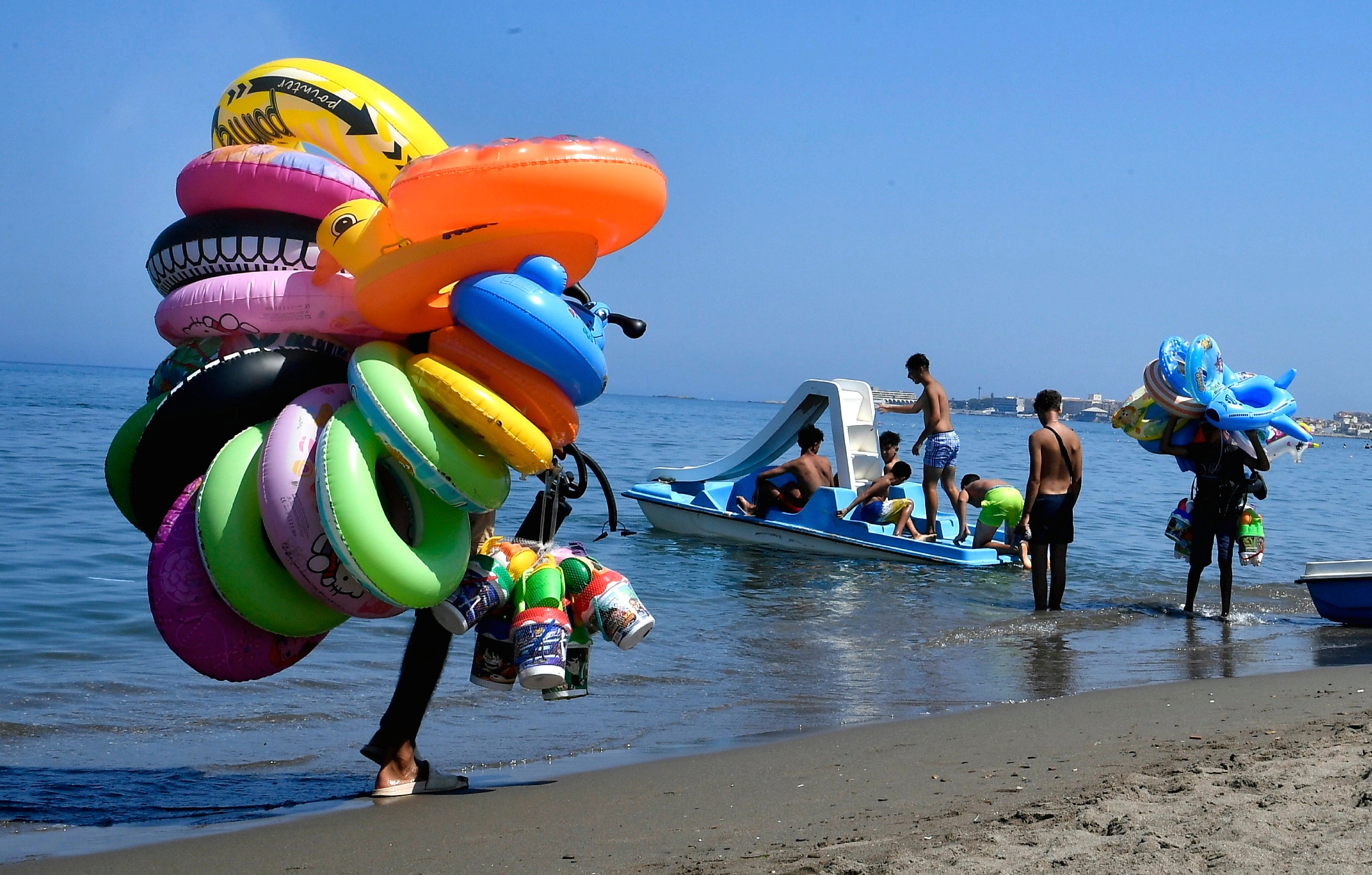 Vendors walk on the beach in Algiers