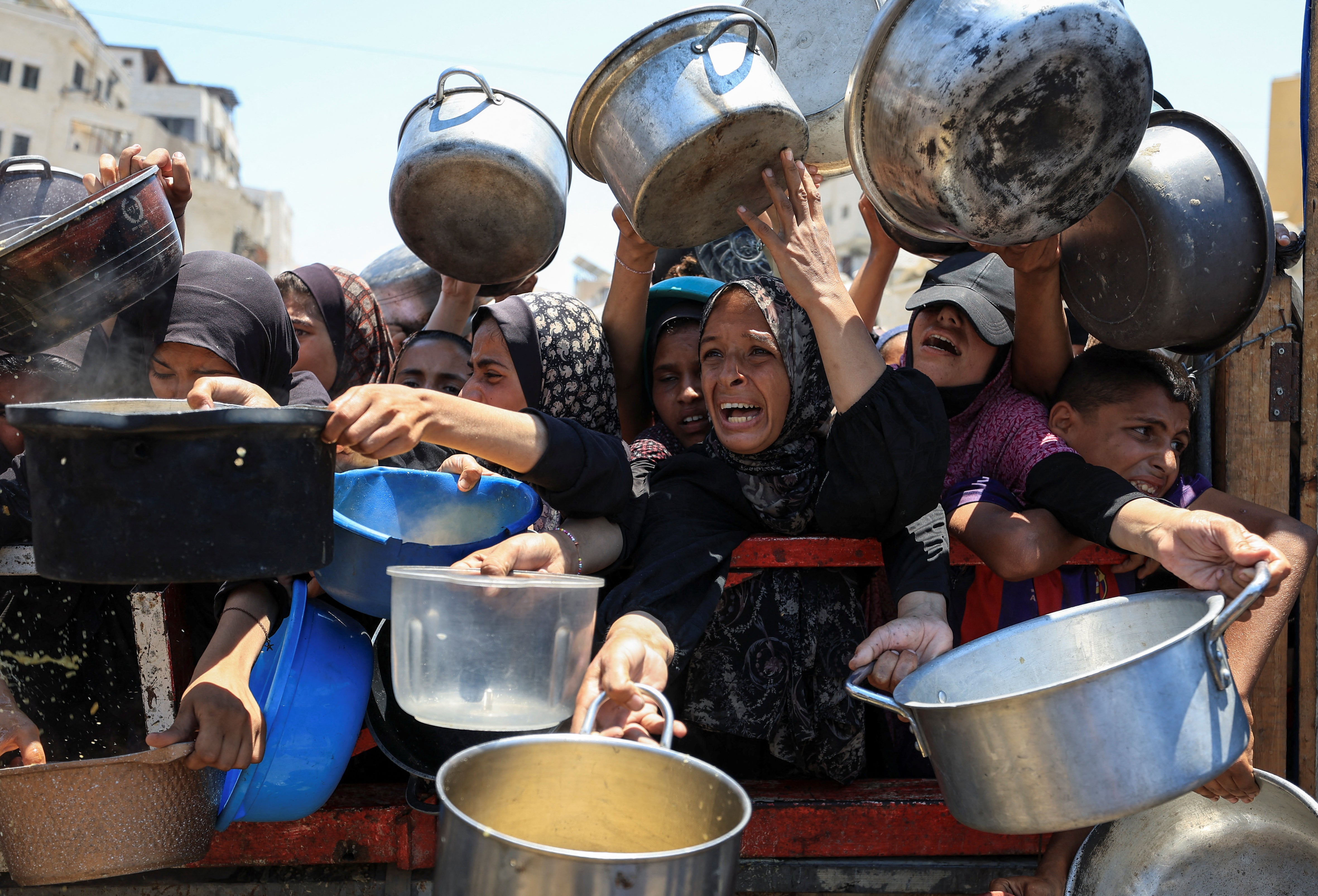 Palestinians gather to receive food from a charity kitchen in Gaza