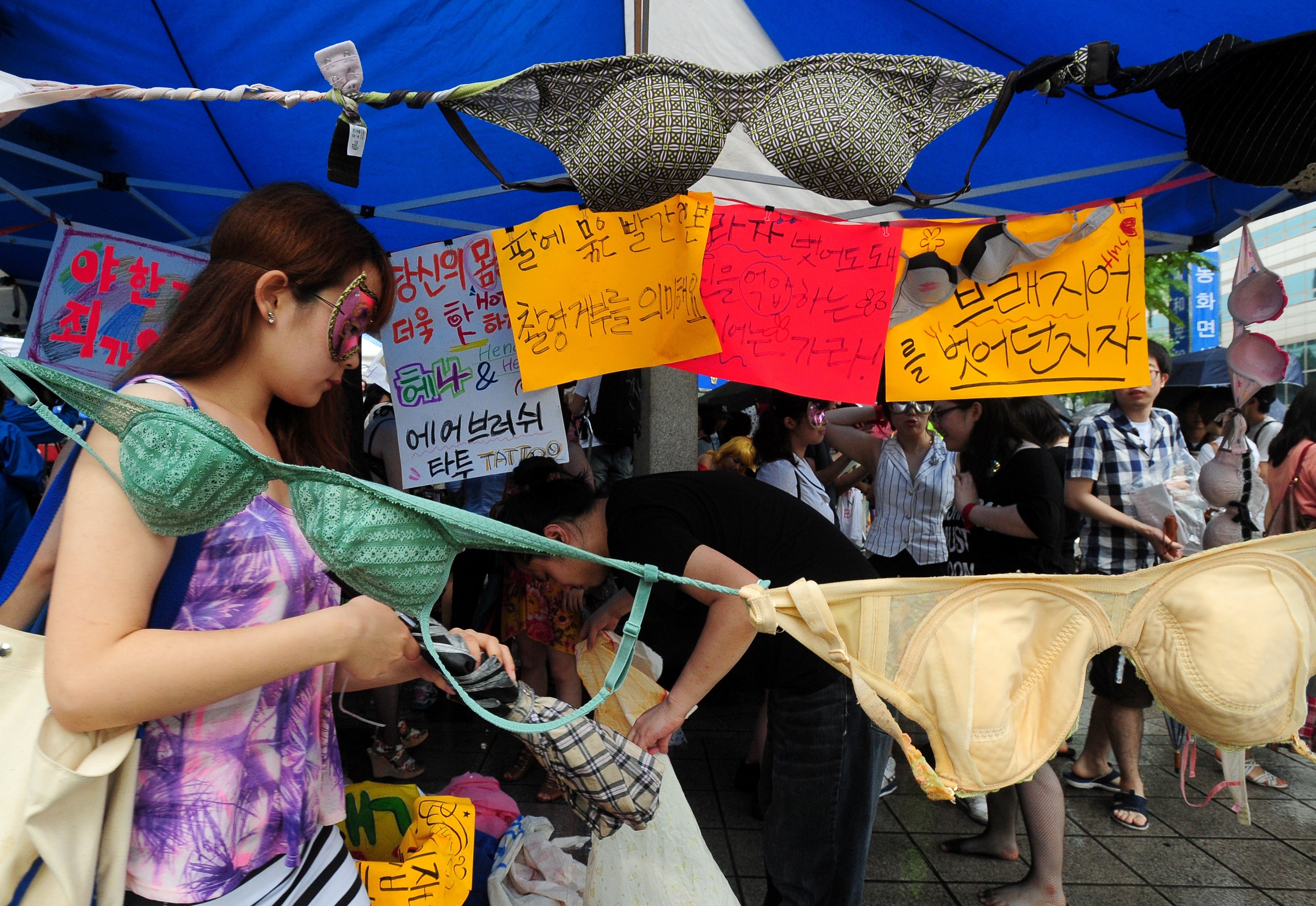 A South Korean woman walks past banners and tied bras during a rally protesting sexual violence in Seoul on 16 July 2011