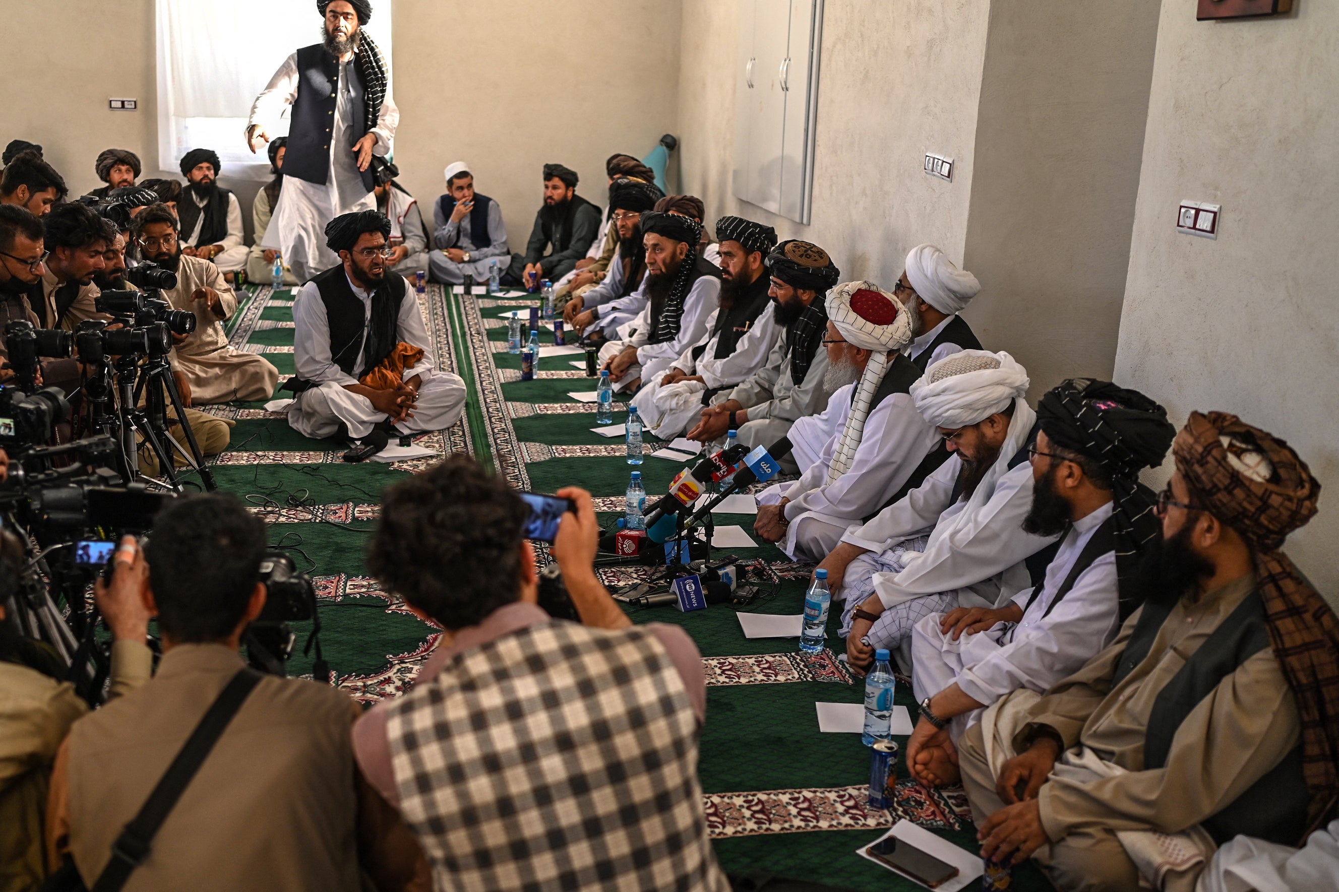 Deputy prime minister of the Taliban Abdul Salam Hanafi (4R) speaks with media during his visit to the Islam Qala border crossing between Afghanistan and Iran
